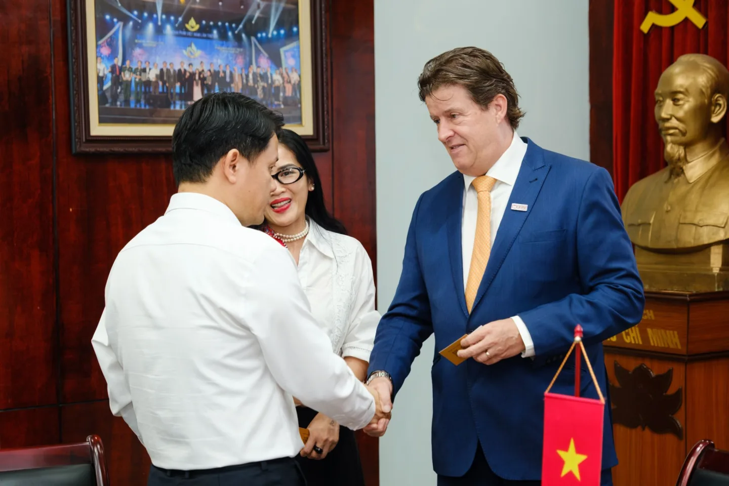 BUV representative in a blue suit greets Vietnamese officials at a formal meeting in Ho Chi Minh City.
