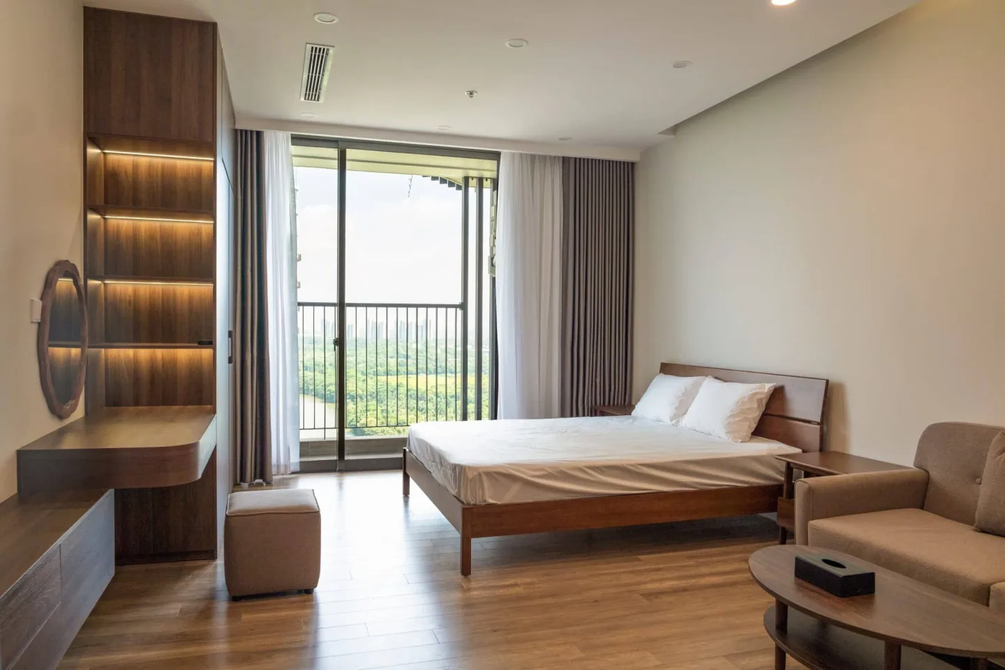Modern BUV Student Accommodation apartment with a bed, sofa, vanity desk, illuminated shelving, and a balcony.
