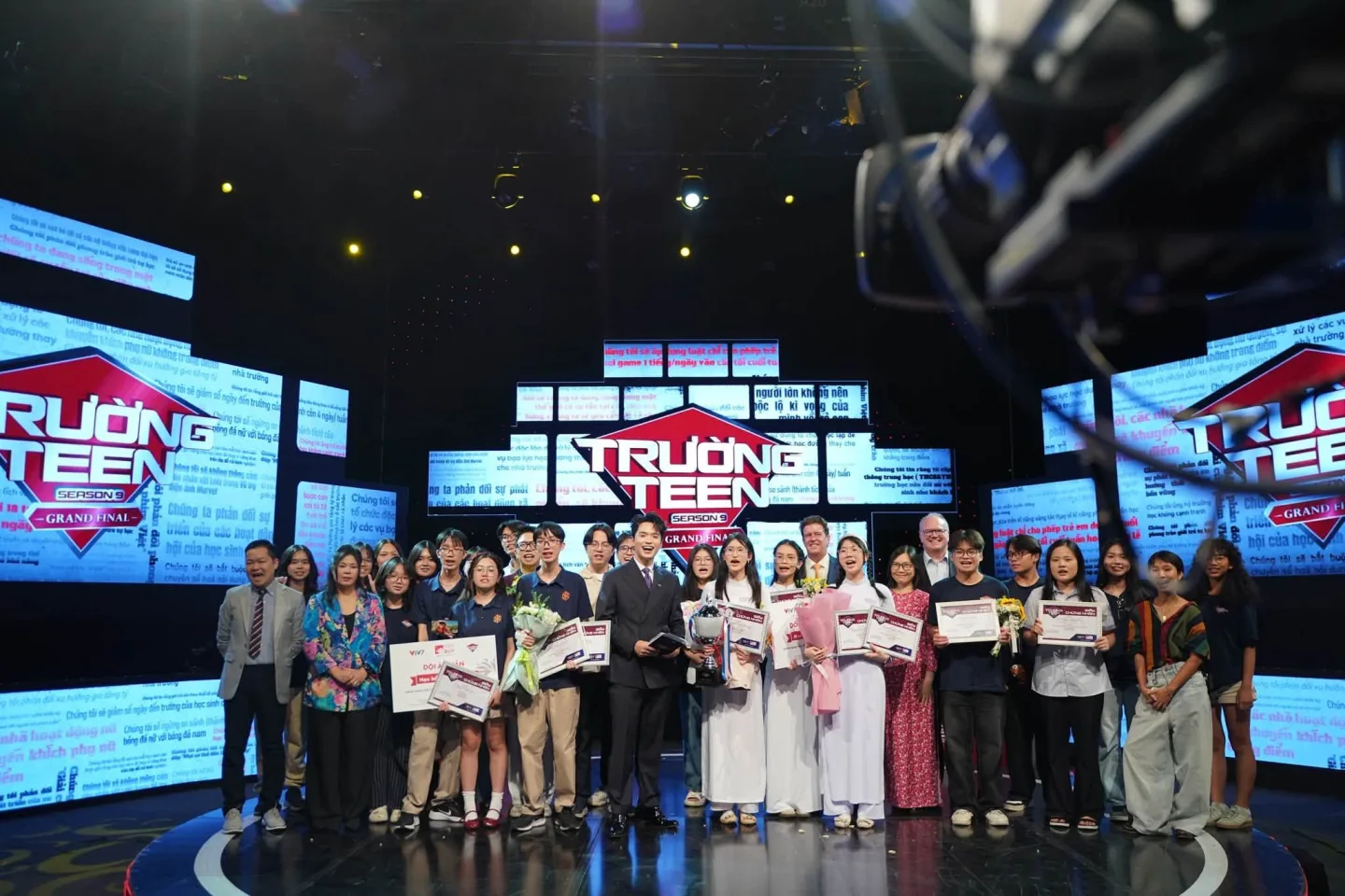 Students and educators celebrate the Trường Teen Season 9 grand final on stage, holding awards and certificates.