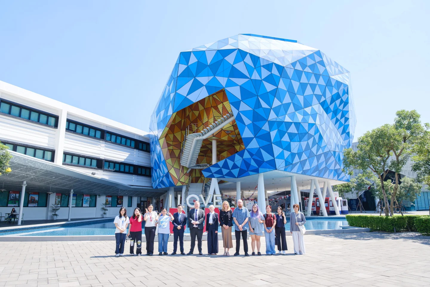 BUV and Manchester Metropolitan University students pose together outside BUV’s modern campus building in Vietnam.