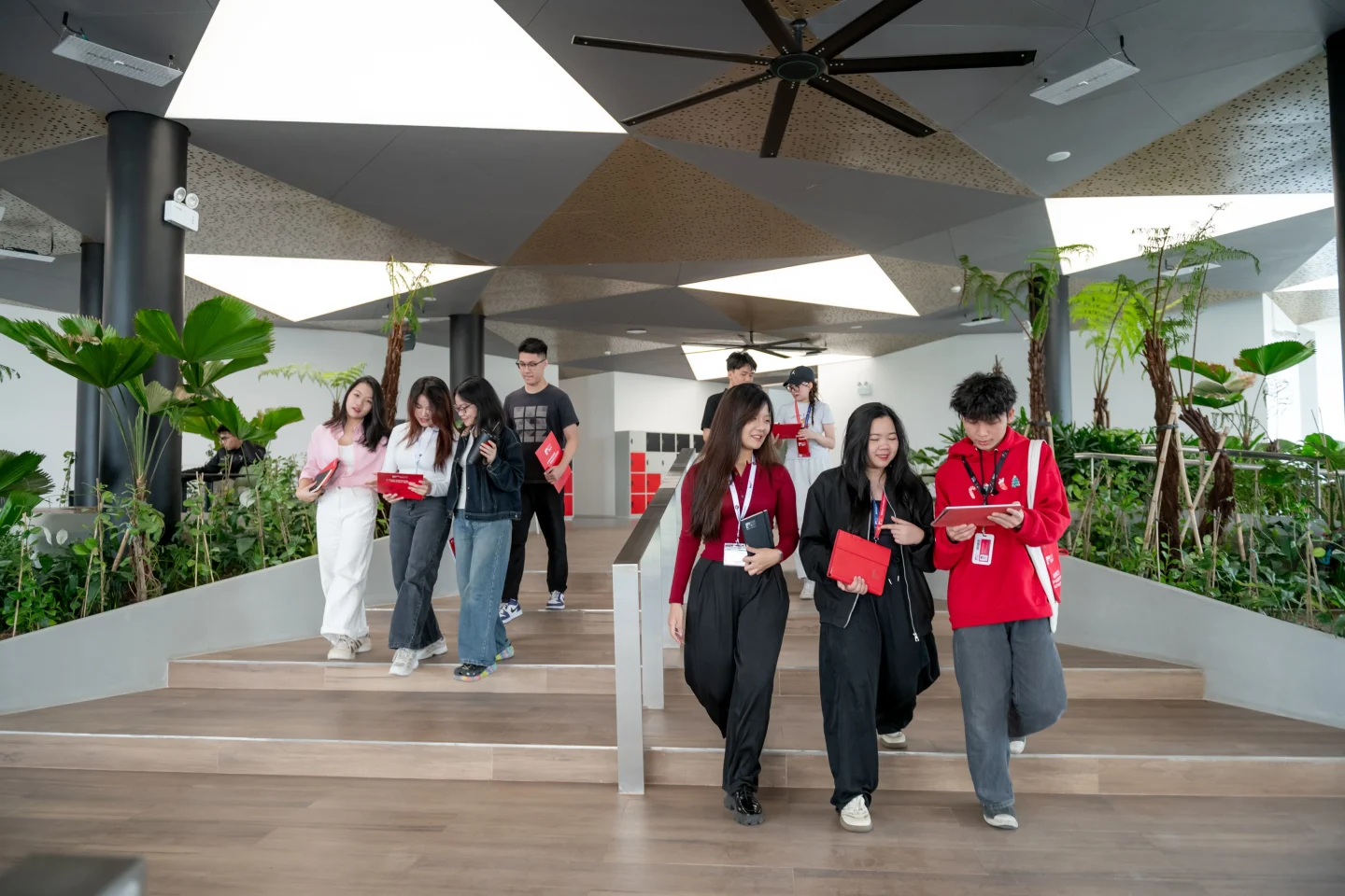 BUV students exploring the university’s modern campus atrium in Hanoi, surrounded by indoor greenery.