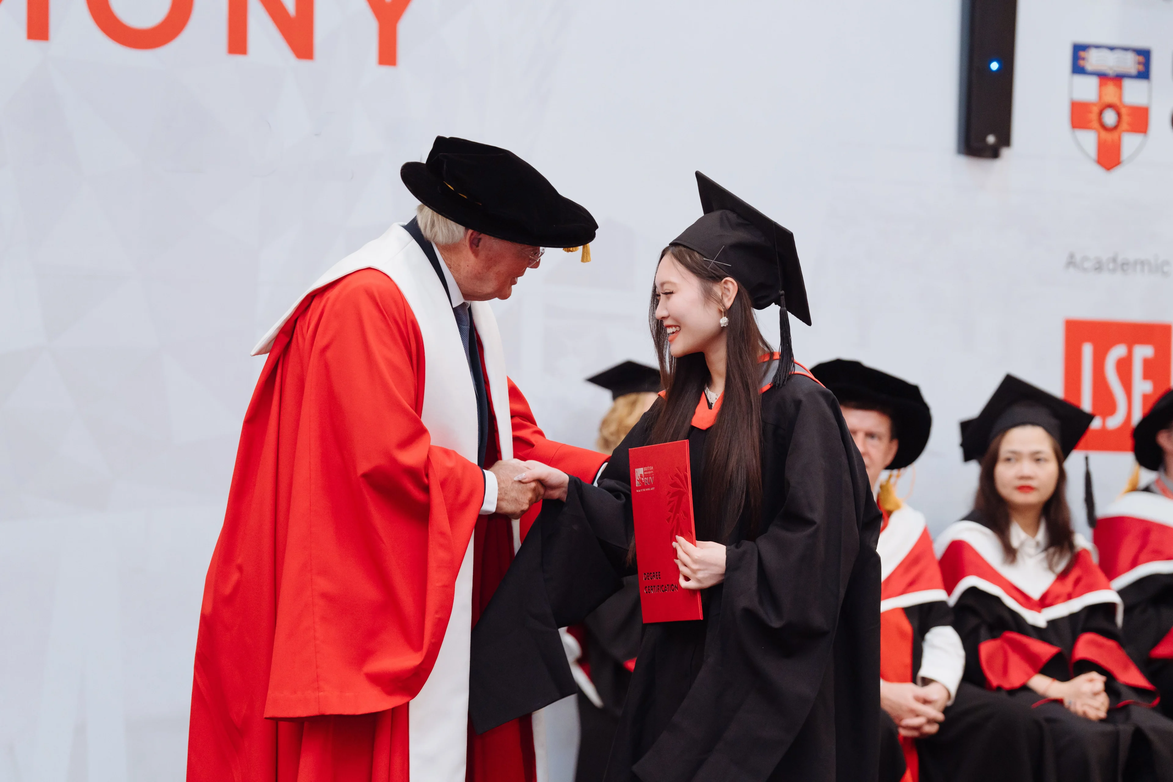 British University Vietnam graduate receiving her diploma at a graduation ceremony