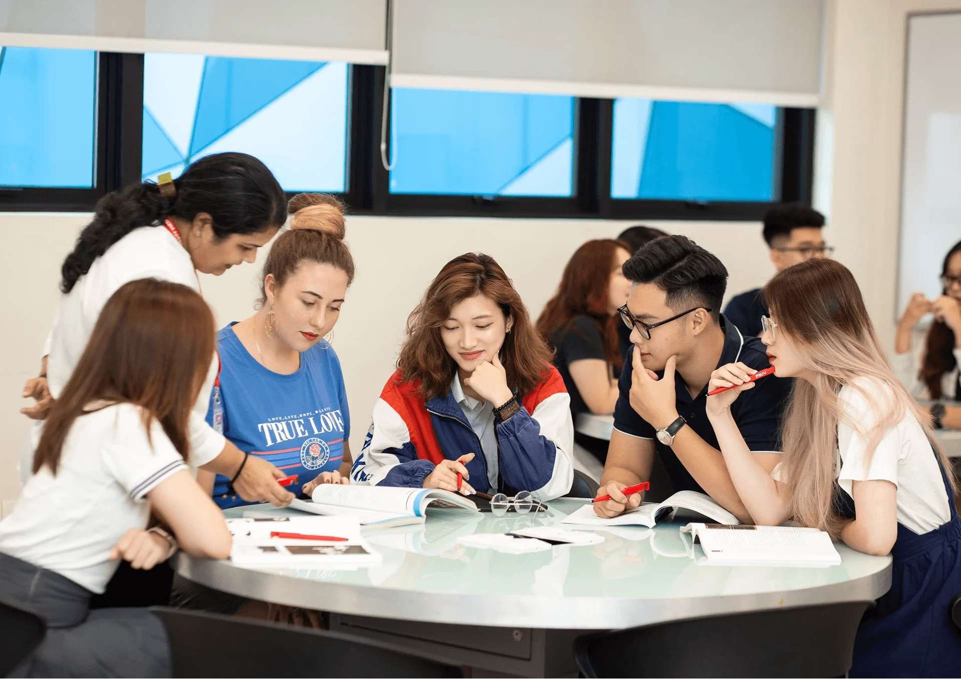 BUV international students collaborating in a classroom discussion around a table.