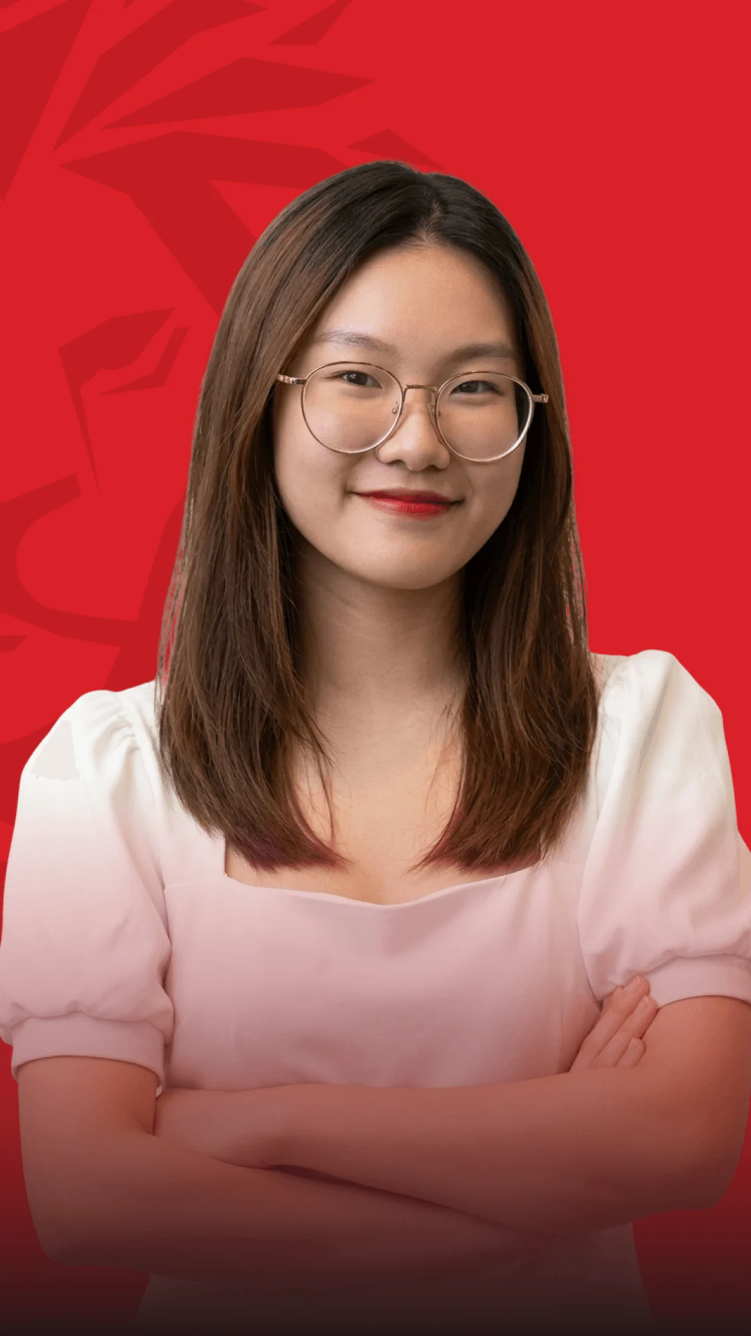 Portrait of a BU‌V alumna wearing glasses, standing in front of a red background.