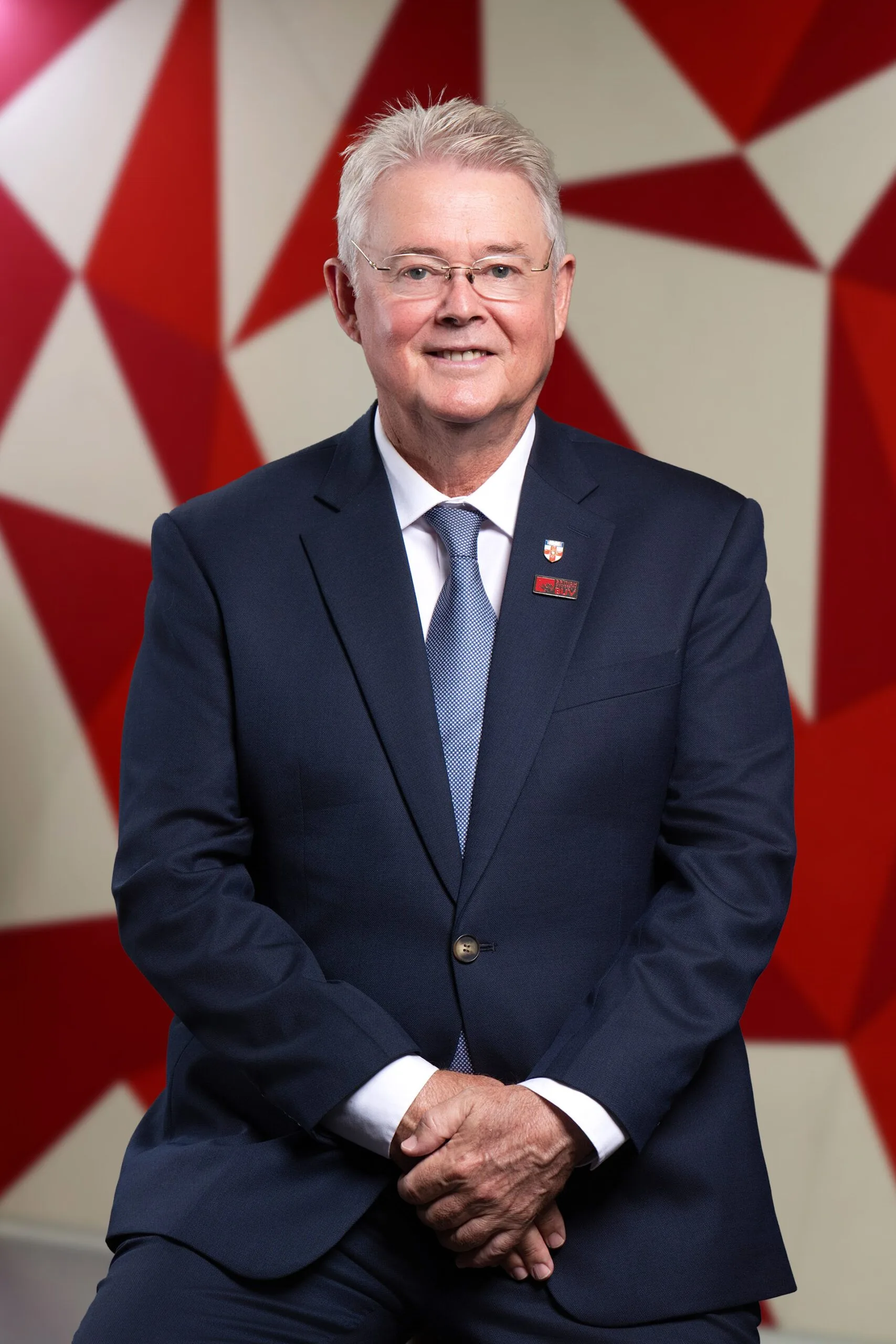 R.D. Gordon, British University Vietnam leader, wearing a navy suit with BUV lapel pins.