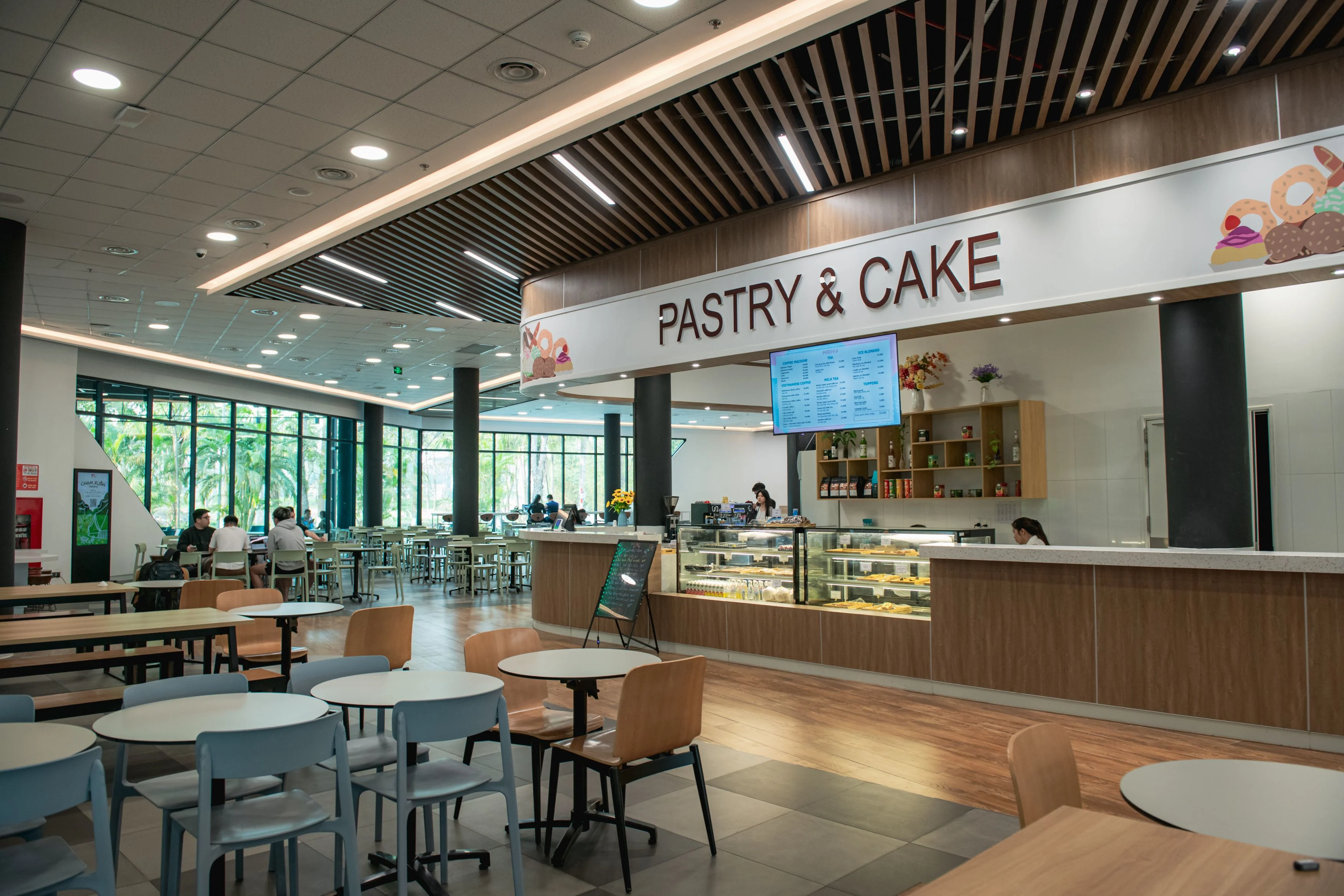 BUV campus Pastry & Cake café with dining tables, bakery counter and students