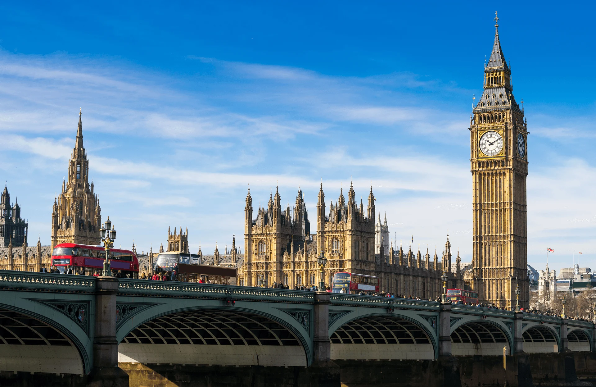 Big Ben and Houses of Parliament in London, UK, viewed from Westminster Bridge with red buses