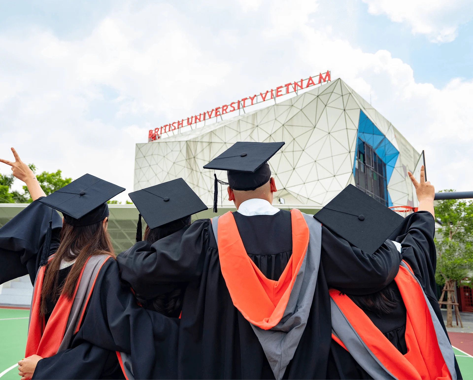 BUV graduates in caps and gowns celebrate outside the British University Vietnam campus.