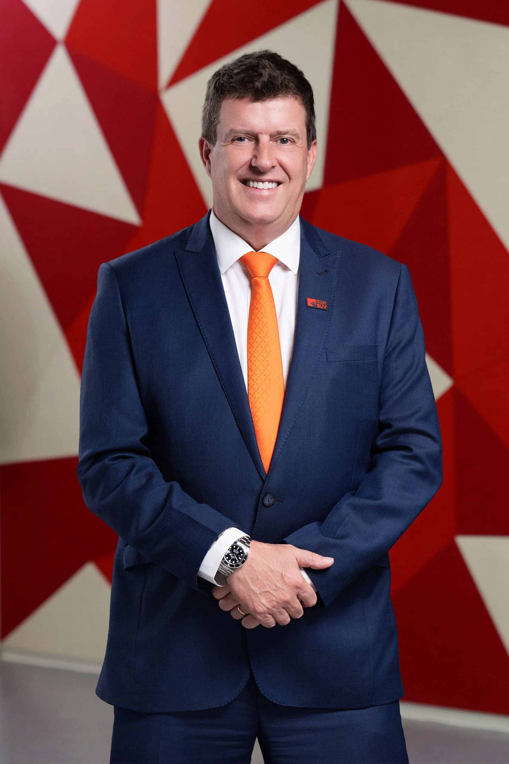 Rick Bennett mặc vest xanh, cà vạt cam tại British University Vietnam (BUV)