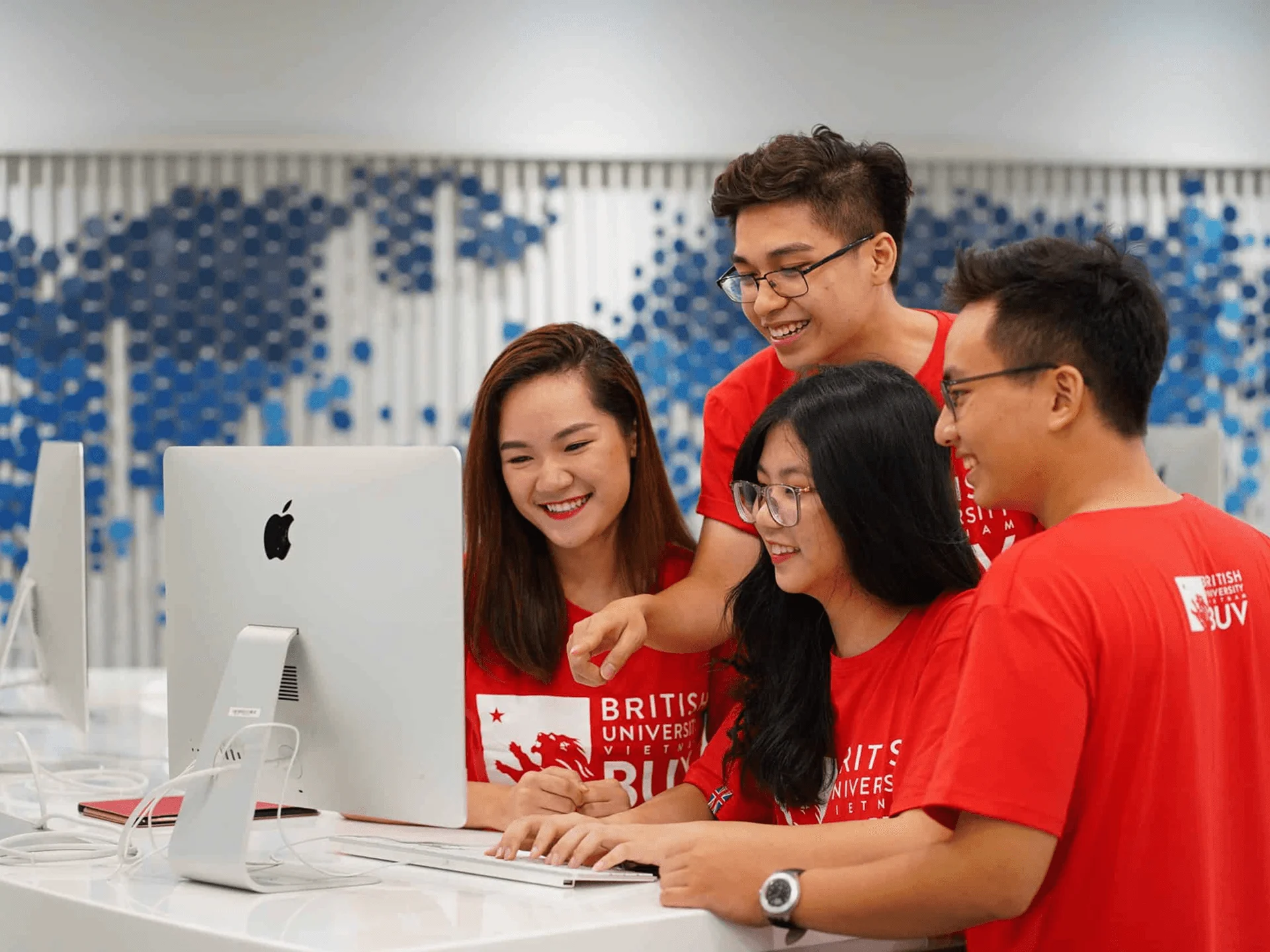 BUV students collaborating on a computer during an international university programme in Vietnam
