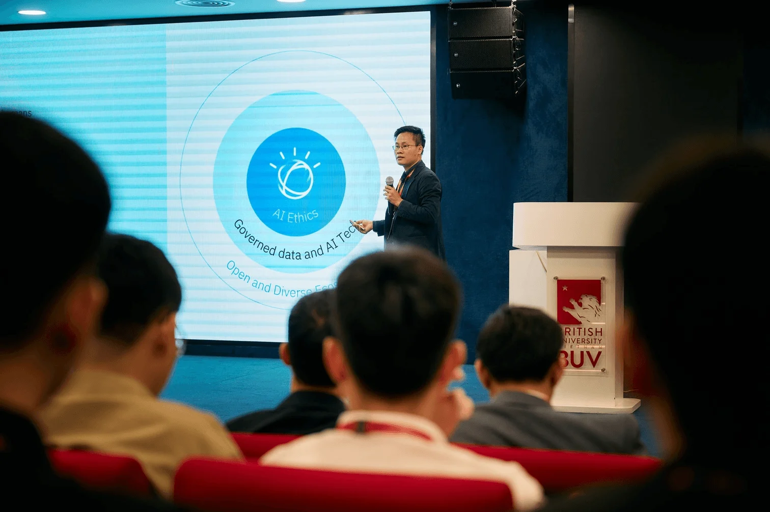 A speaker presents on artificial intelligence and data to an audience at a British University Vietnam career event.