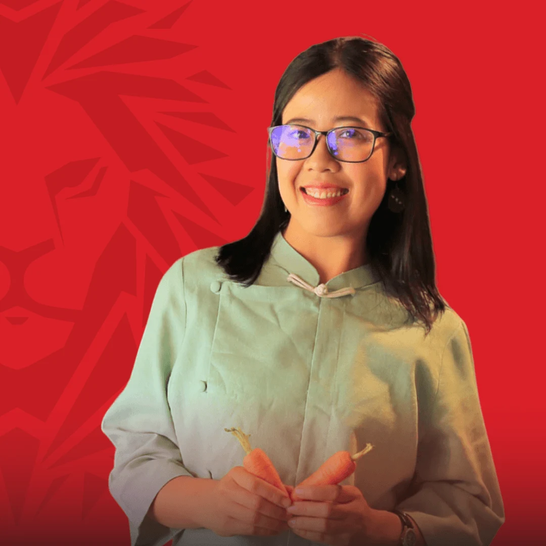 Chân dung nữ cựu sinh viên BUV mỉm cười trên nền đỏ thương hiệu British University Vietnam.