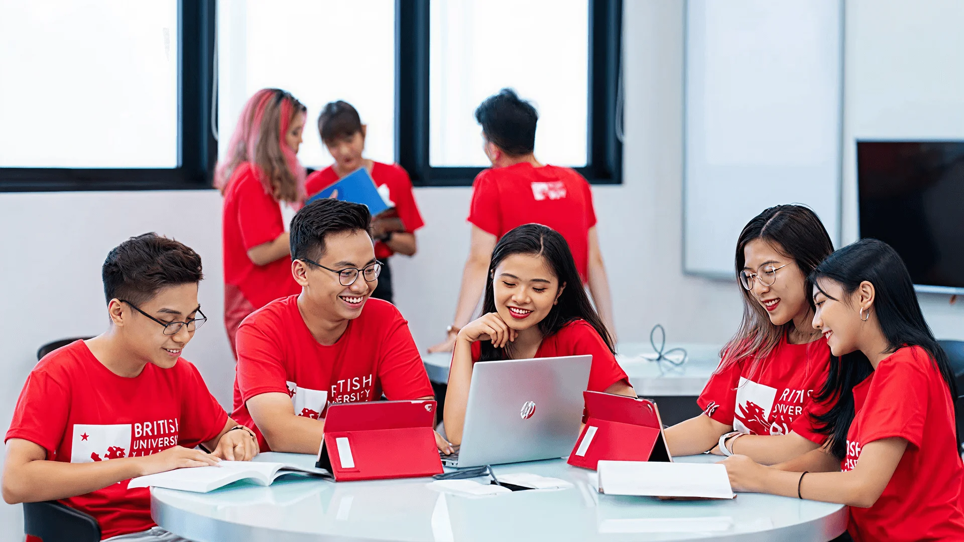 BUV undergraduate students collaborating in a classroom with laptops and textbooks at British University Vietnam