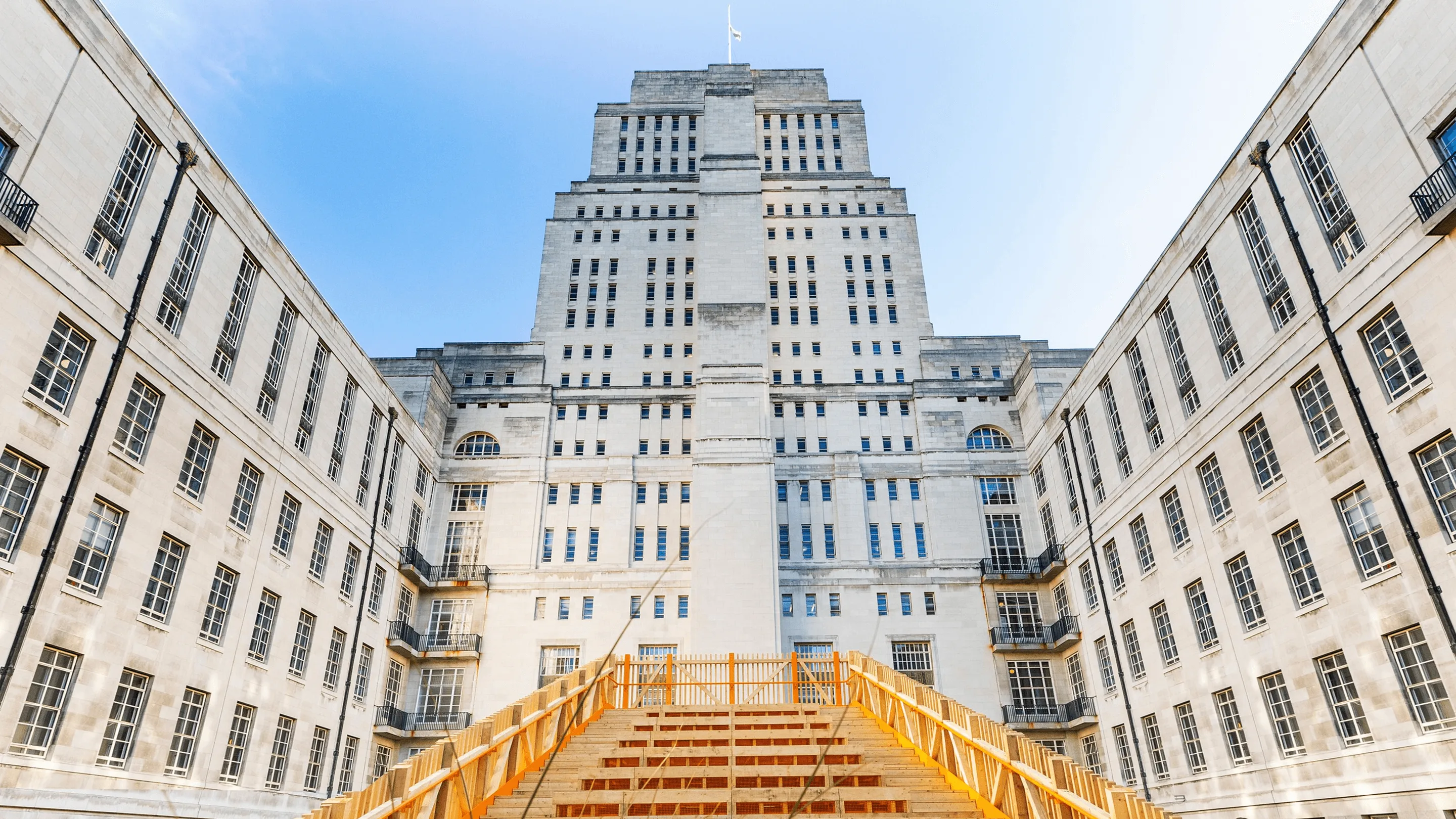 University of London Senate House campus building with grand wooden steps under a clear blue sky