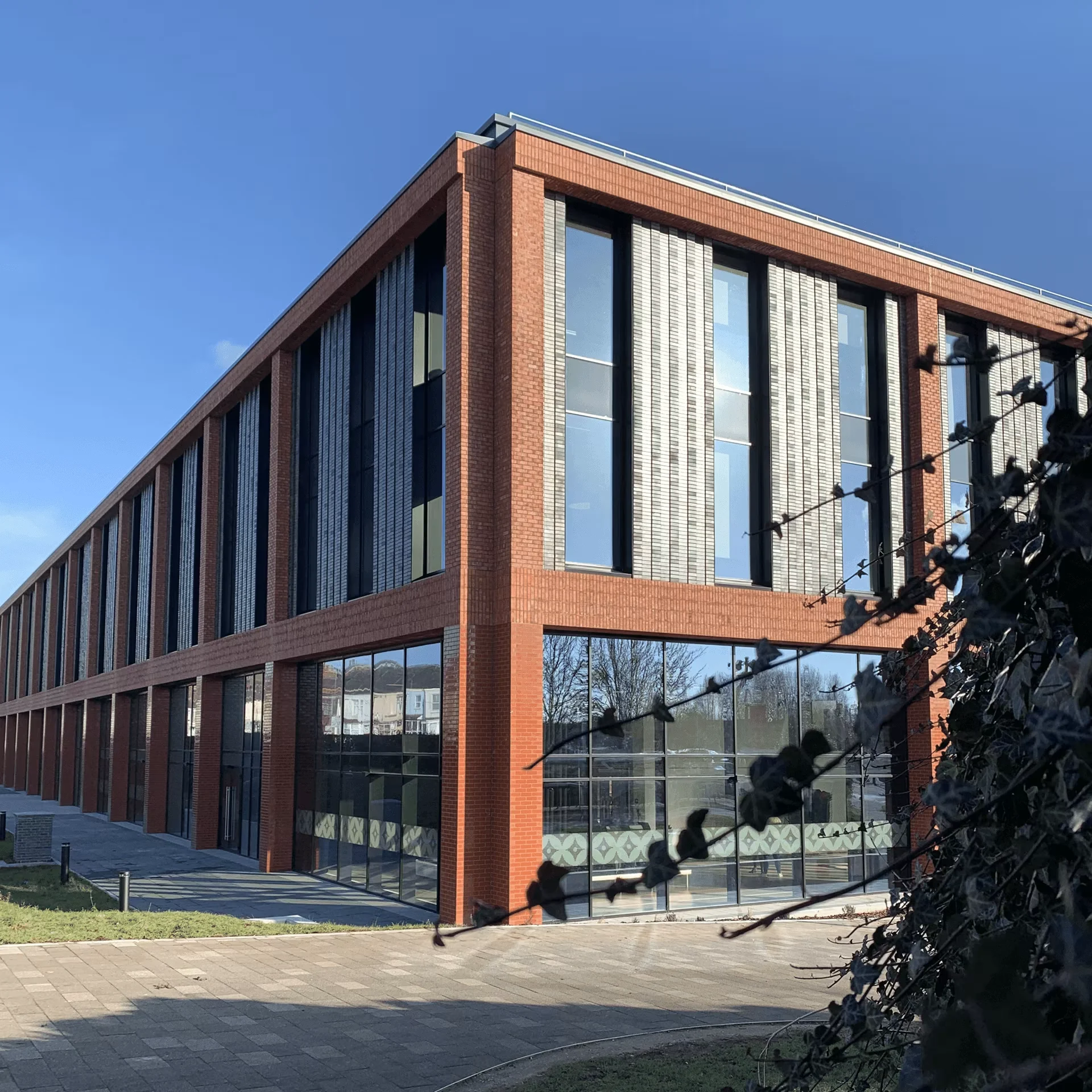 Modern red-brick Staffordshire University campus building under a clear blue sky