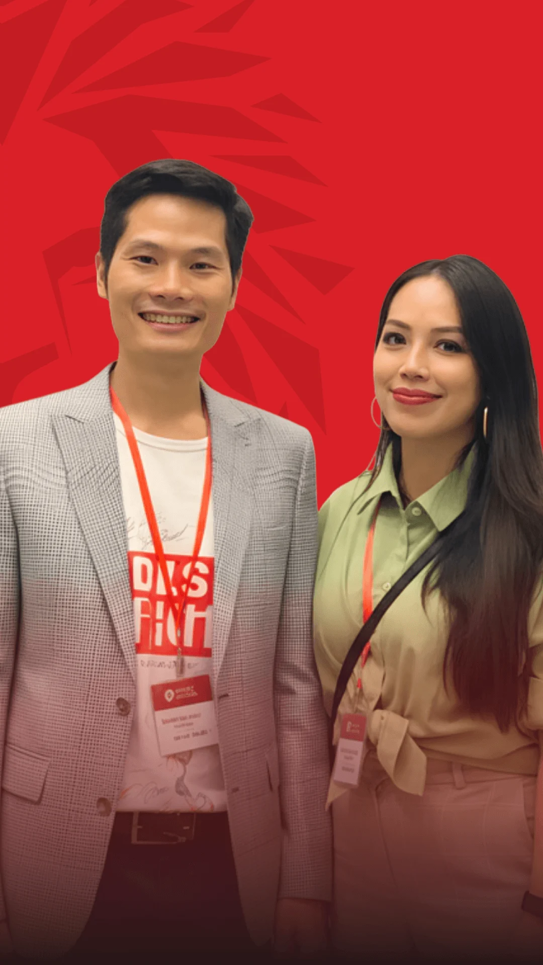 Alumni photo of two BUV graduates standing together against a red backdrop, smiling and wearing event badges.