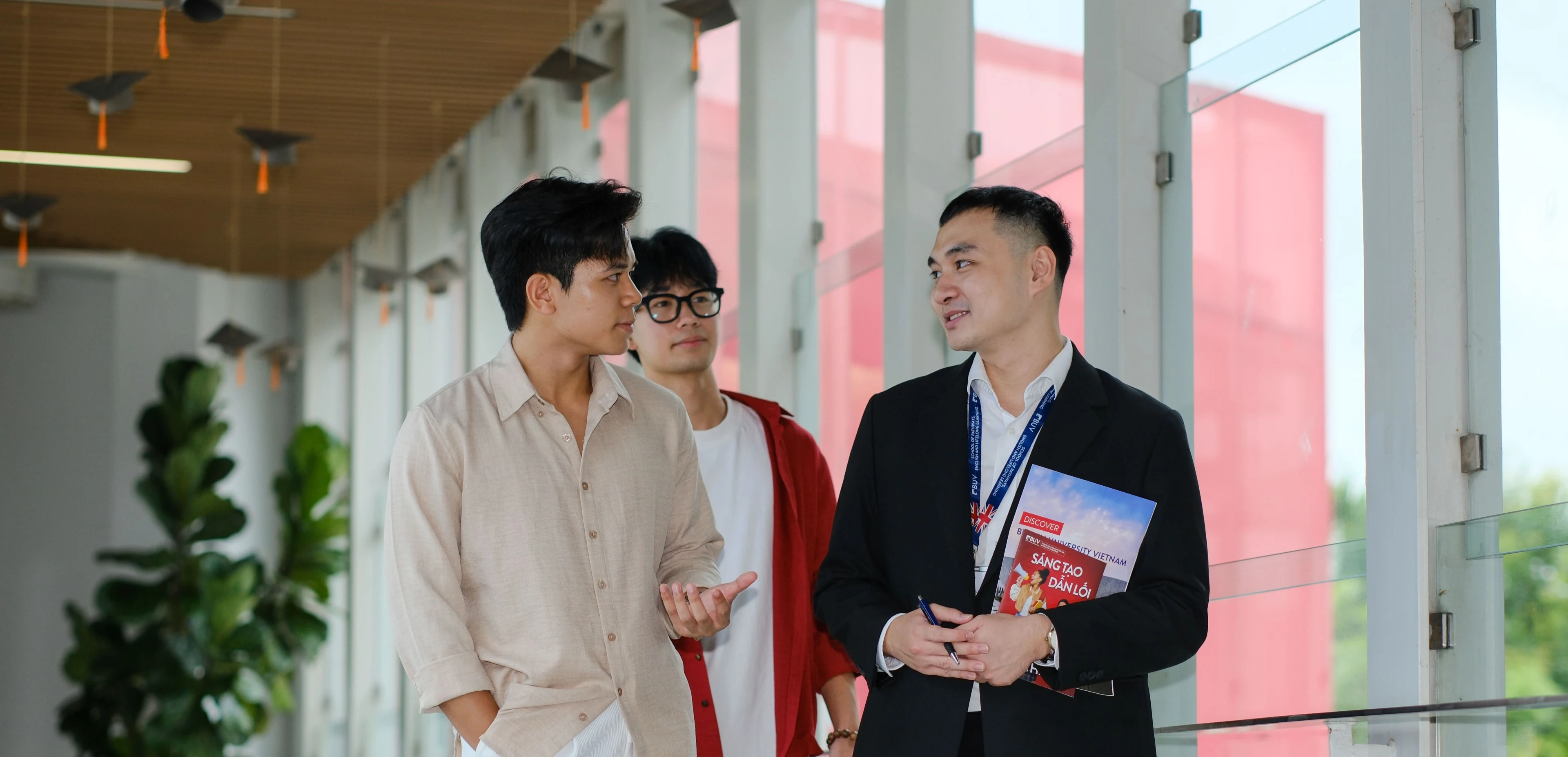 Cố vấn BUV trò chuyện cùng hai sinh viên tại hành lang khuôn viên trường đại học quốc tế.