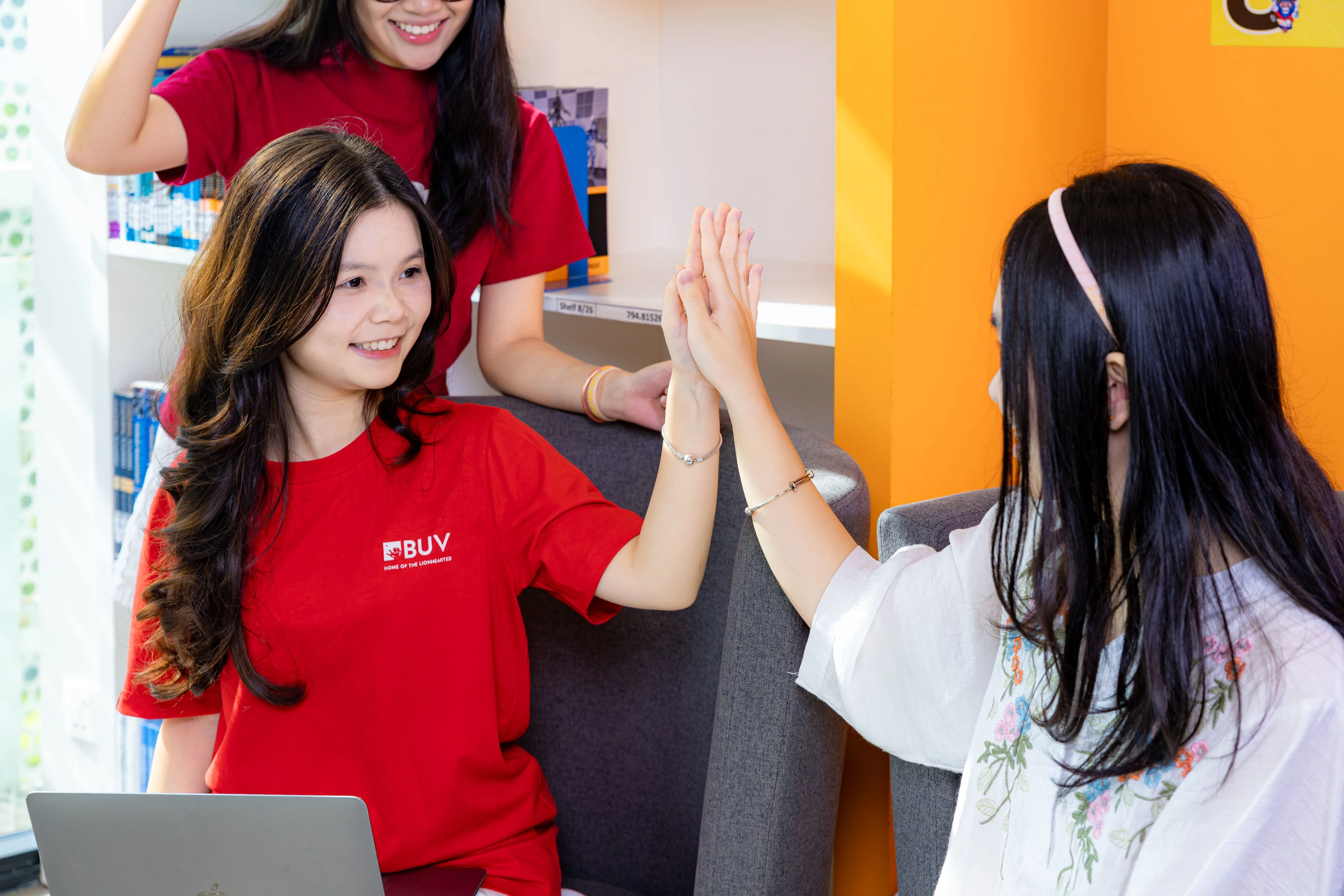 BUV student ambassador high-fives a visitor during a campus activity at British University Vietnam.