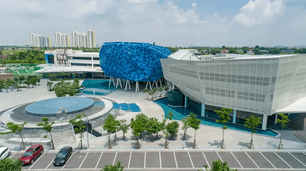 Aerial view of BUV campus facilities with modern buildings, swimming pools, and landscaped grounds in Vietnam