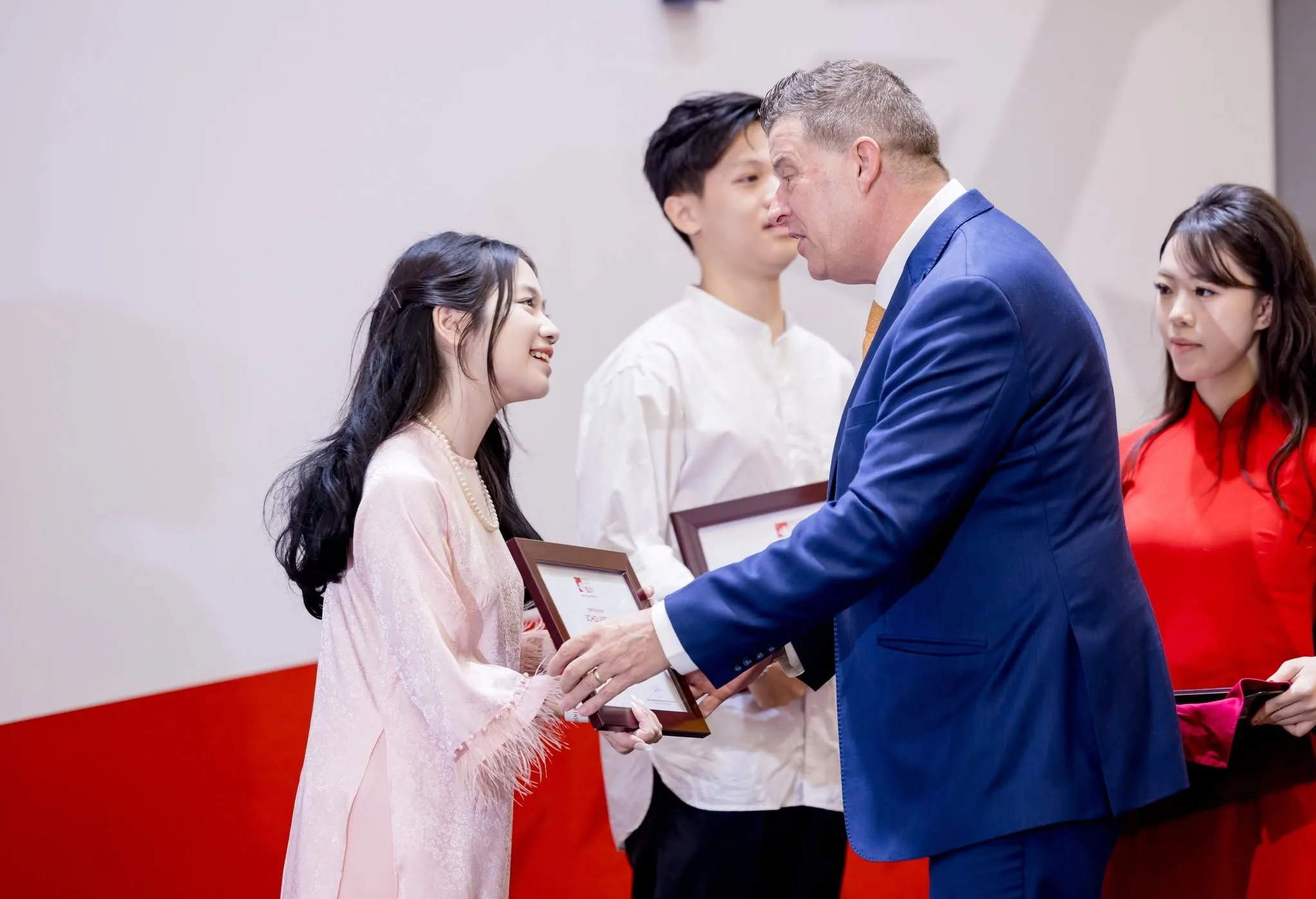 Nguyen Tra My receives the BUV Vice-Chancellor Scholarship certificate at an award ceremony.