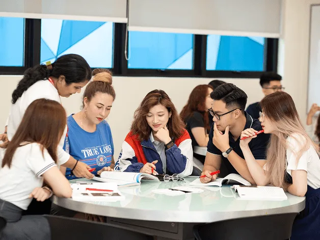 BUV students collaborate in an international classroom discussion around a table