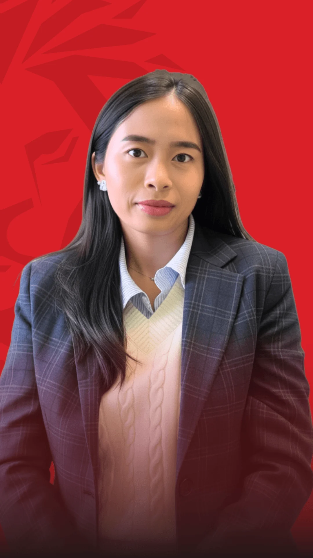 Nữ cựu sinh viên British University Vietnam mặc blazer kẻ, đứng trước nền đỏ.