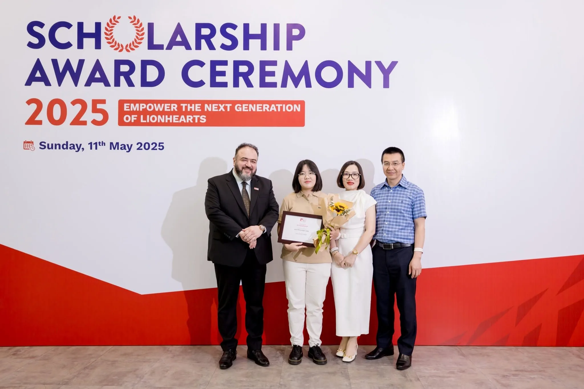 Nguyen Khanh Linh receives a scholarship award at BUV Scholarship Award Ceremony 2025 with family and guests.