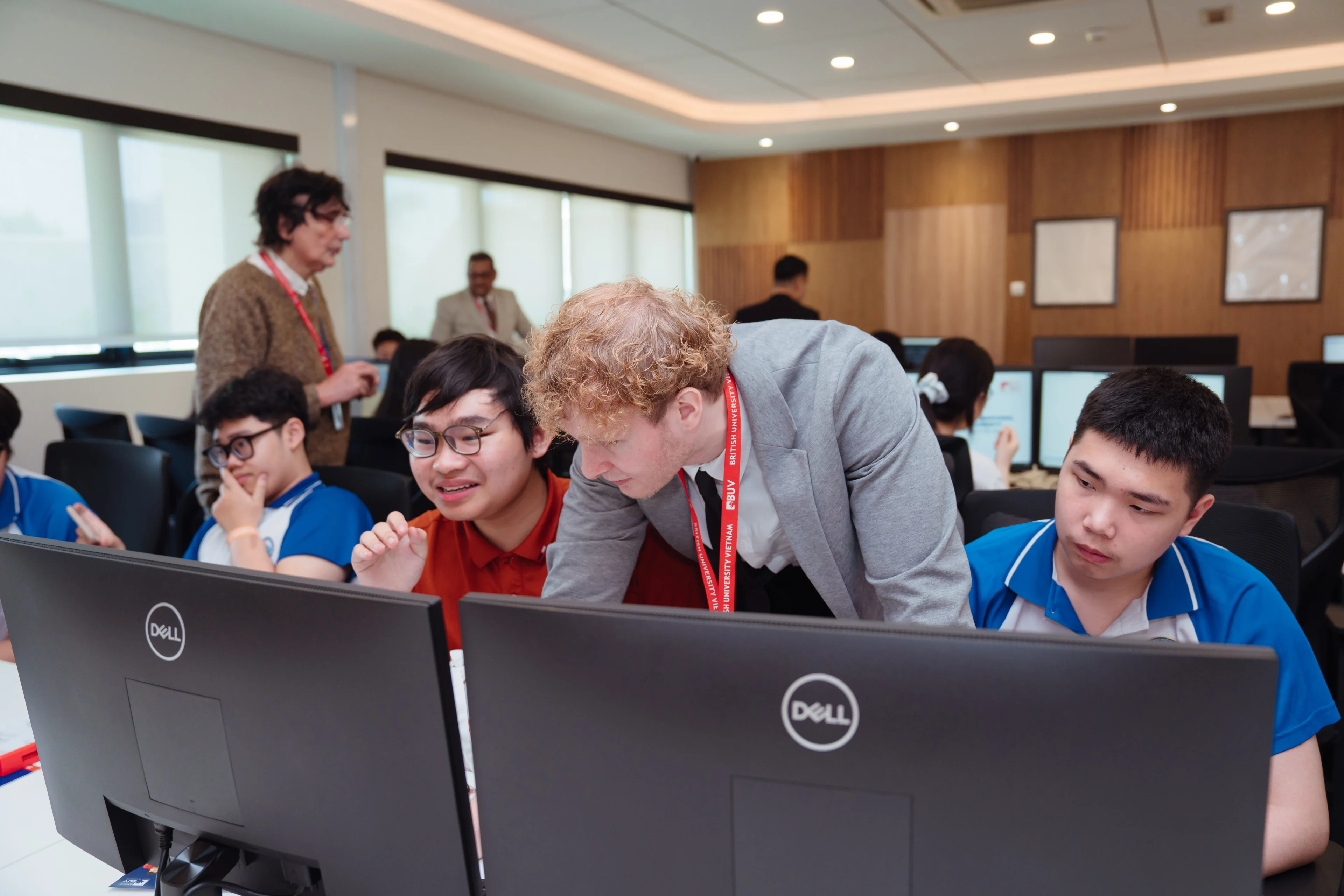 BUV students collaborate with an international lecturer in a computer lab during a practical learning session