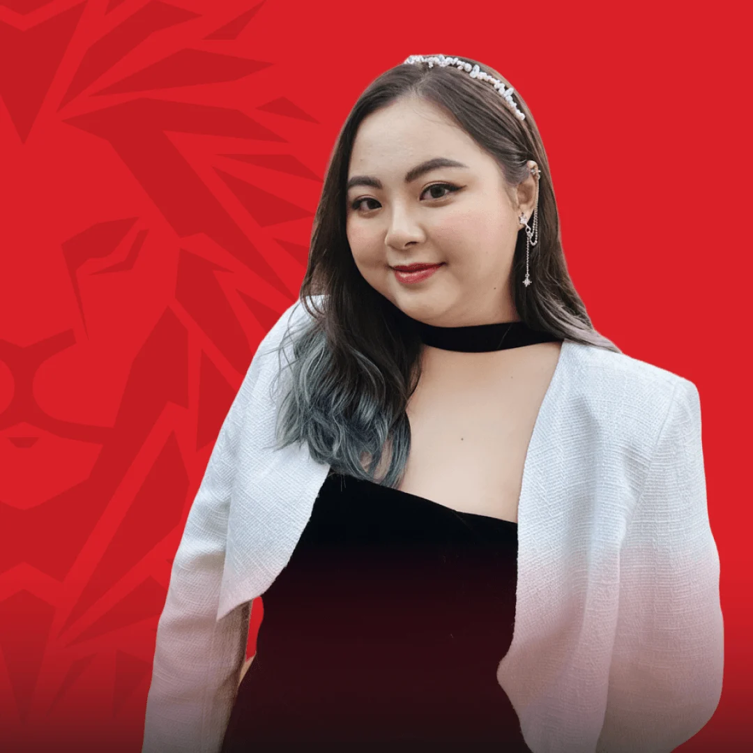 BUV alumna portrait in a white blazer against a red British University Vietnam background