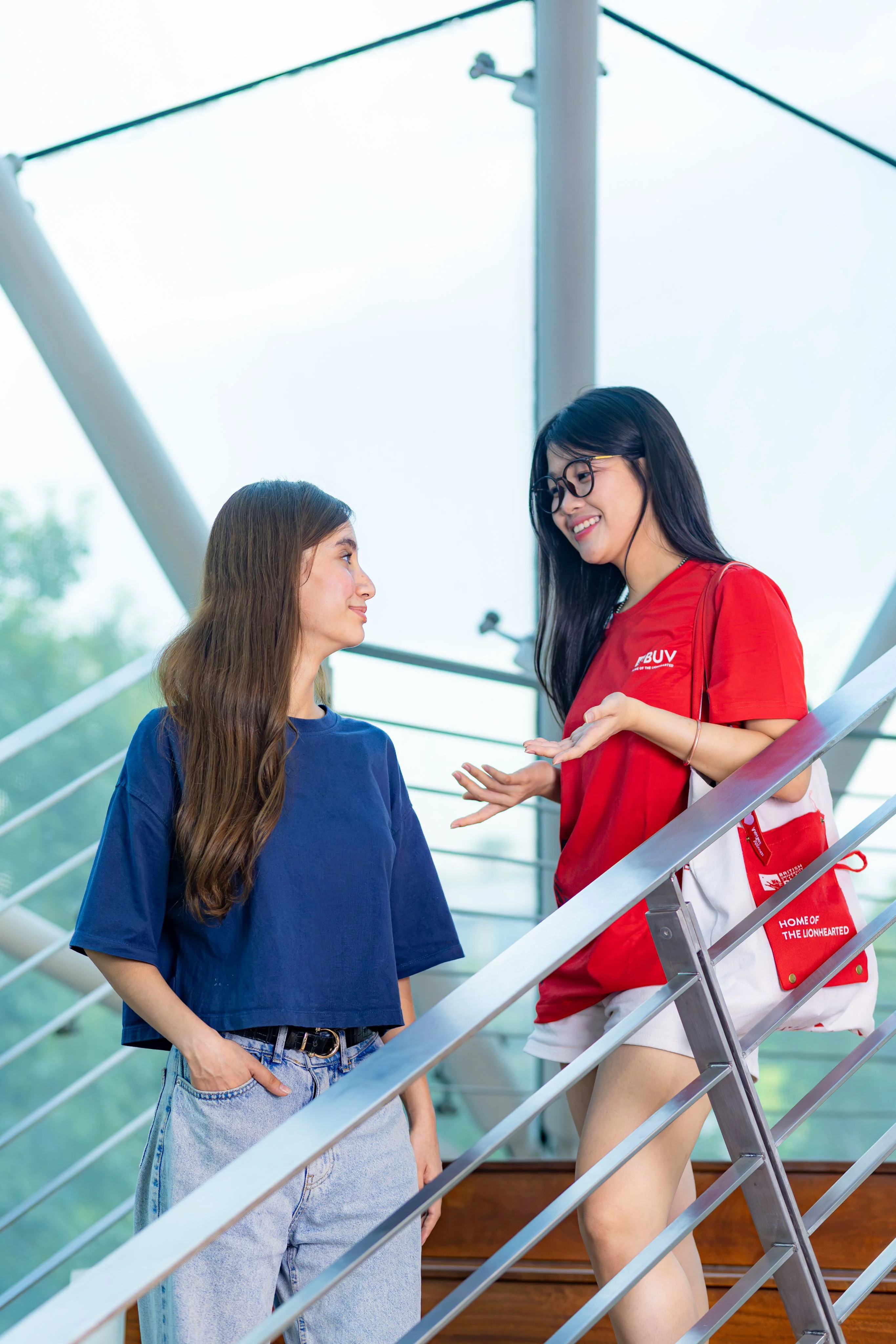 Hai sinh viên trò chuyện trên cầu thang trong khuôn viên Đại học Anh Quốc Việt Nam BUV