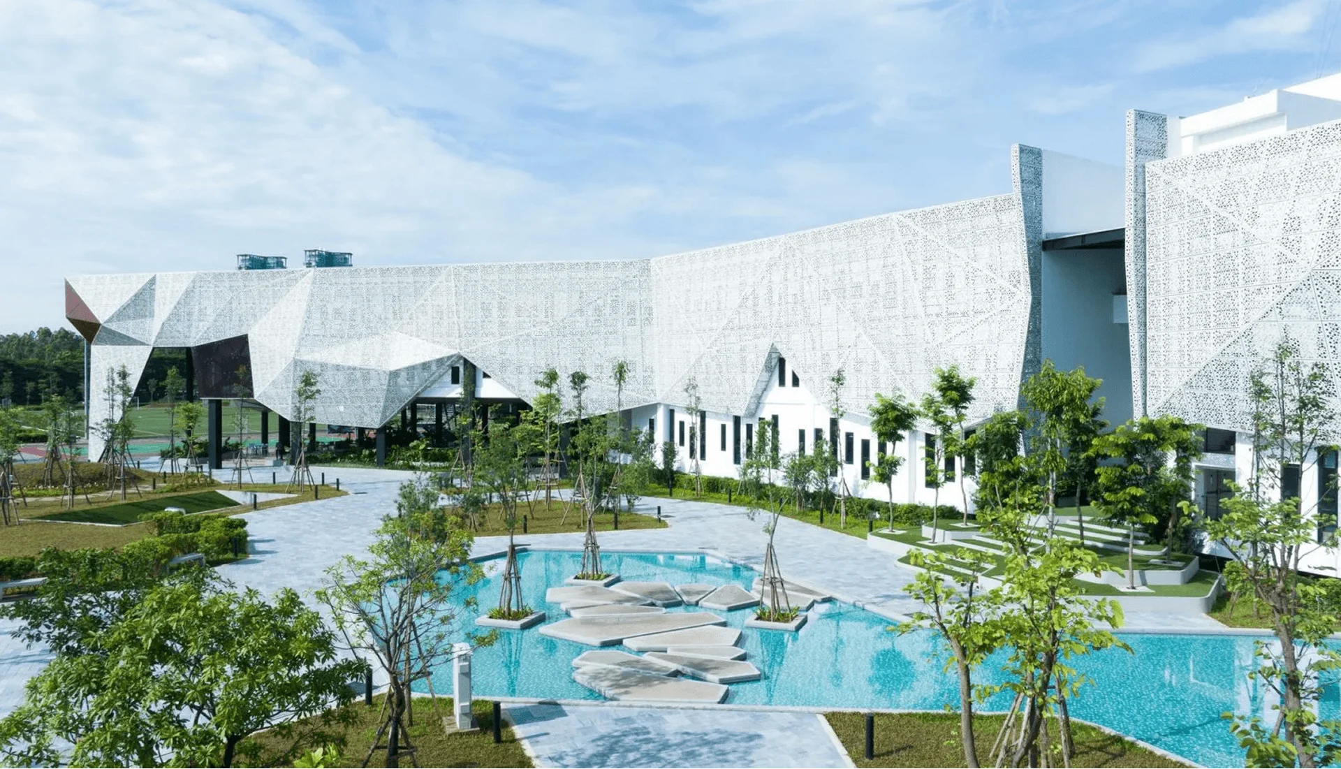 British University Vietnam (BUV) campus with modern white architecture, landscaped gardens and outdoor pool