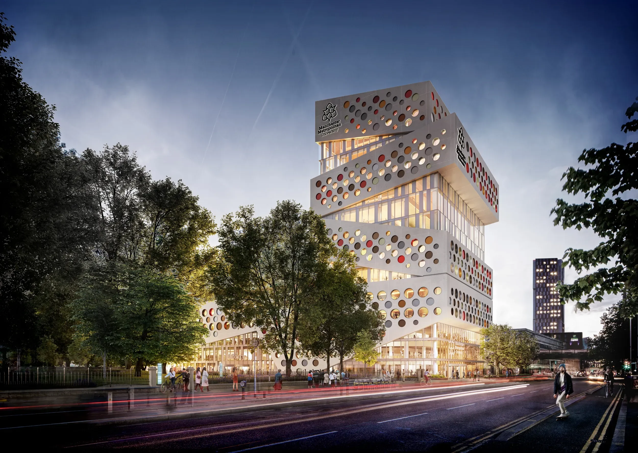 An architectural rendering shows a modern multi-story Manchester Metropolitan University building with distinctive circular cutouts and a stacked, multi-level design. It's set within a park-like environment at twilight, with people and vehicles.