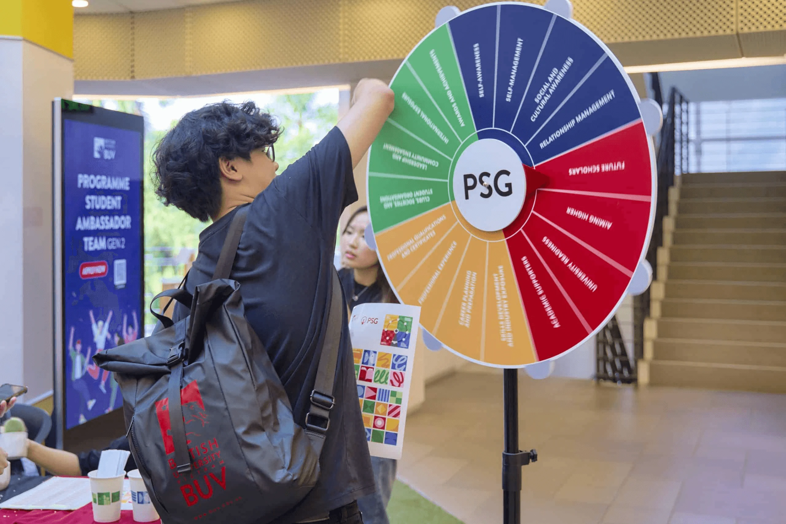 BUV student spinning the PSG programme wheel at a British University Vietnam campus event
