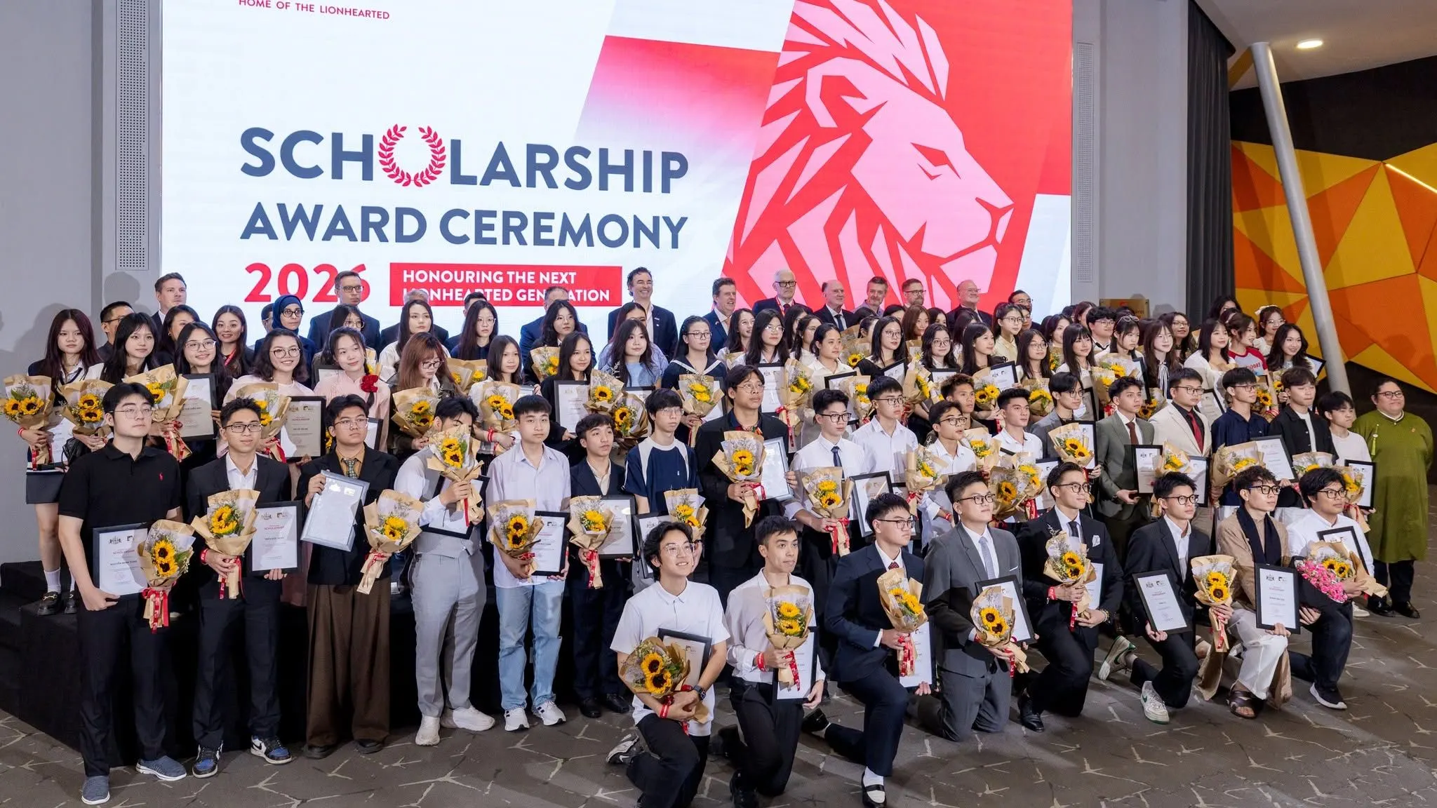 British University Vietnam scholarship recipients at the 2025 award ceremony with certificates and flowers