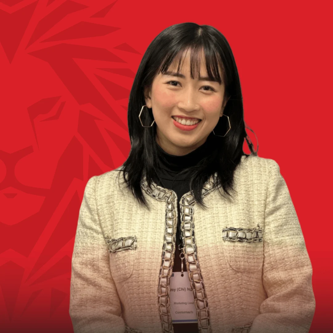 BUV alumna smiling in professional attire against a red British University Vietnam backdrop
