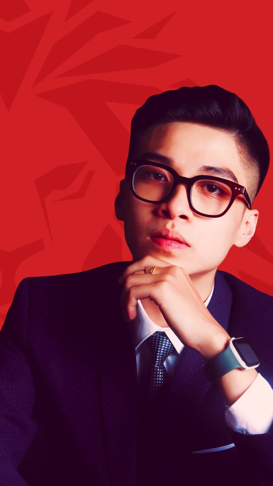 BUV alumnus Nhật Anh in a dark suit and glasses, posing against a red background.