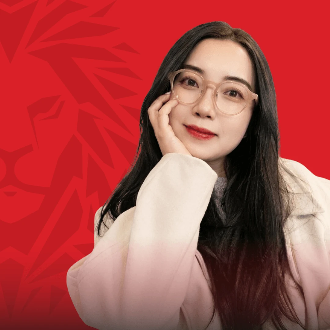 Chân dung nữ cựu sinh viên BUV đeo kính trên nền đỏ thương hiệu British University Vietnam