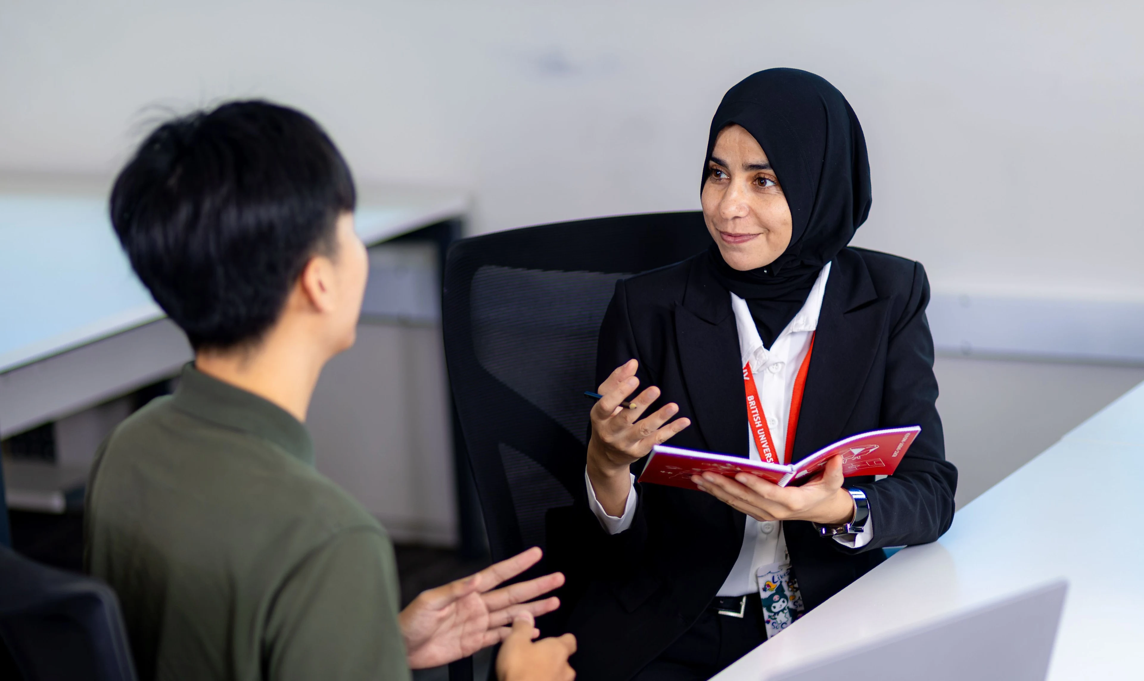 BUV staff member advising a student at a desk during a one-to-one university consultation.