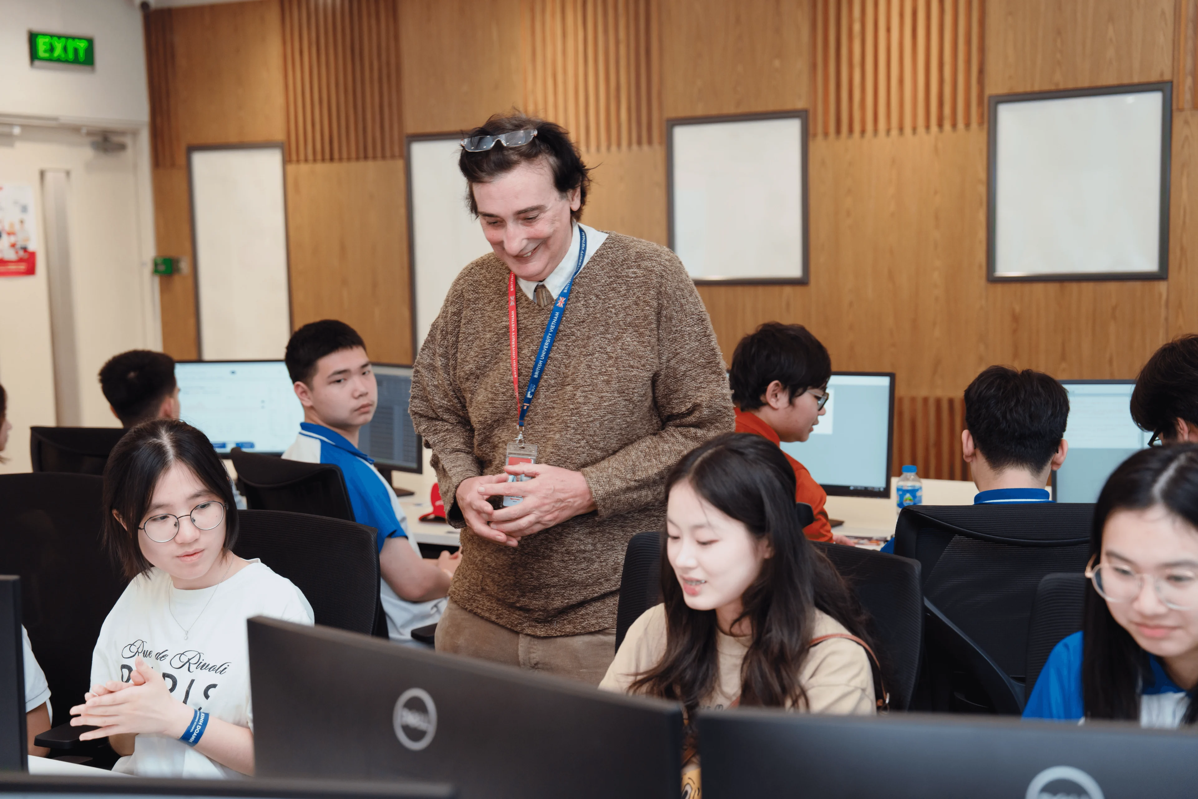 British University Vietnam lecturer guiding students in a computer lab classroom