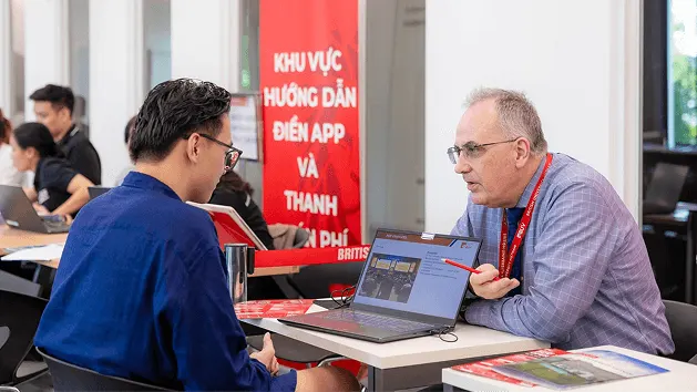 Sinh viên BUV trao đổi với chuyên viên tư vấn tuyển sinh tại khu vực hướng dẫn điền đơn.