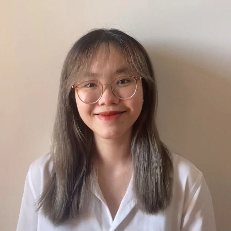 BUV student Nguyen Hoang Khanh Vy smiling in a white shirt and round glasses