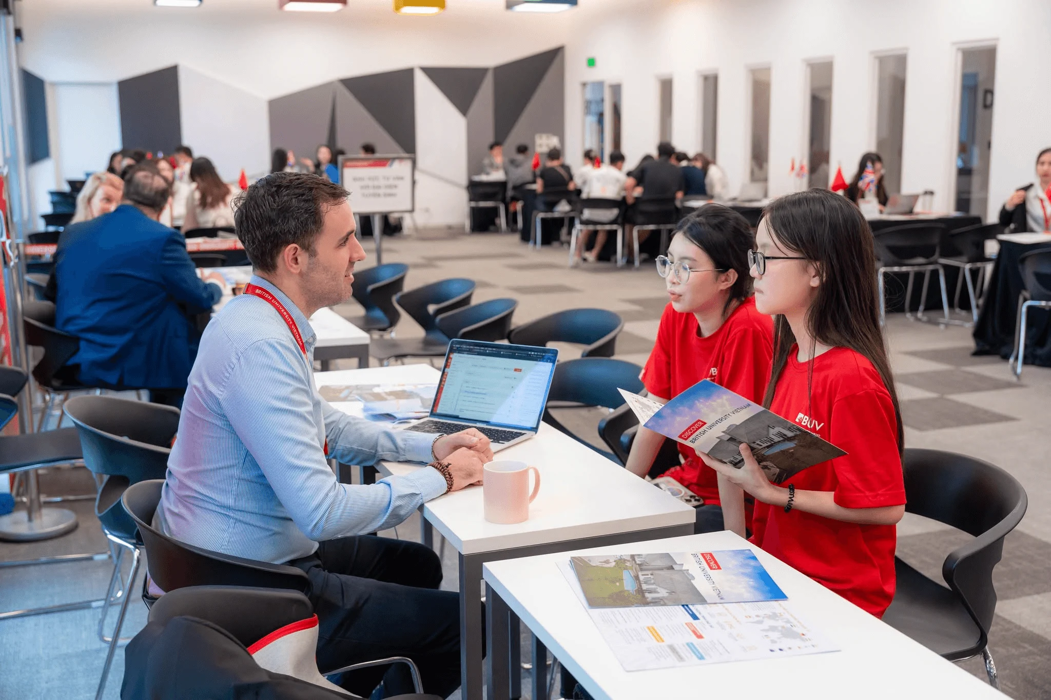 British University Vietnam (BUV) students discuss study programs with an advisor at a university admissions event.