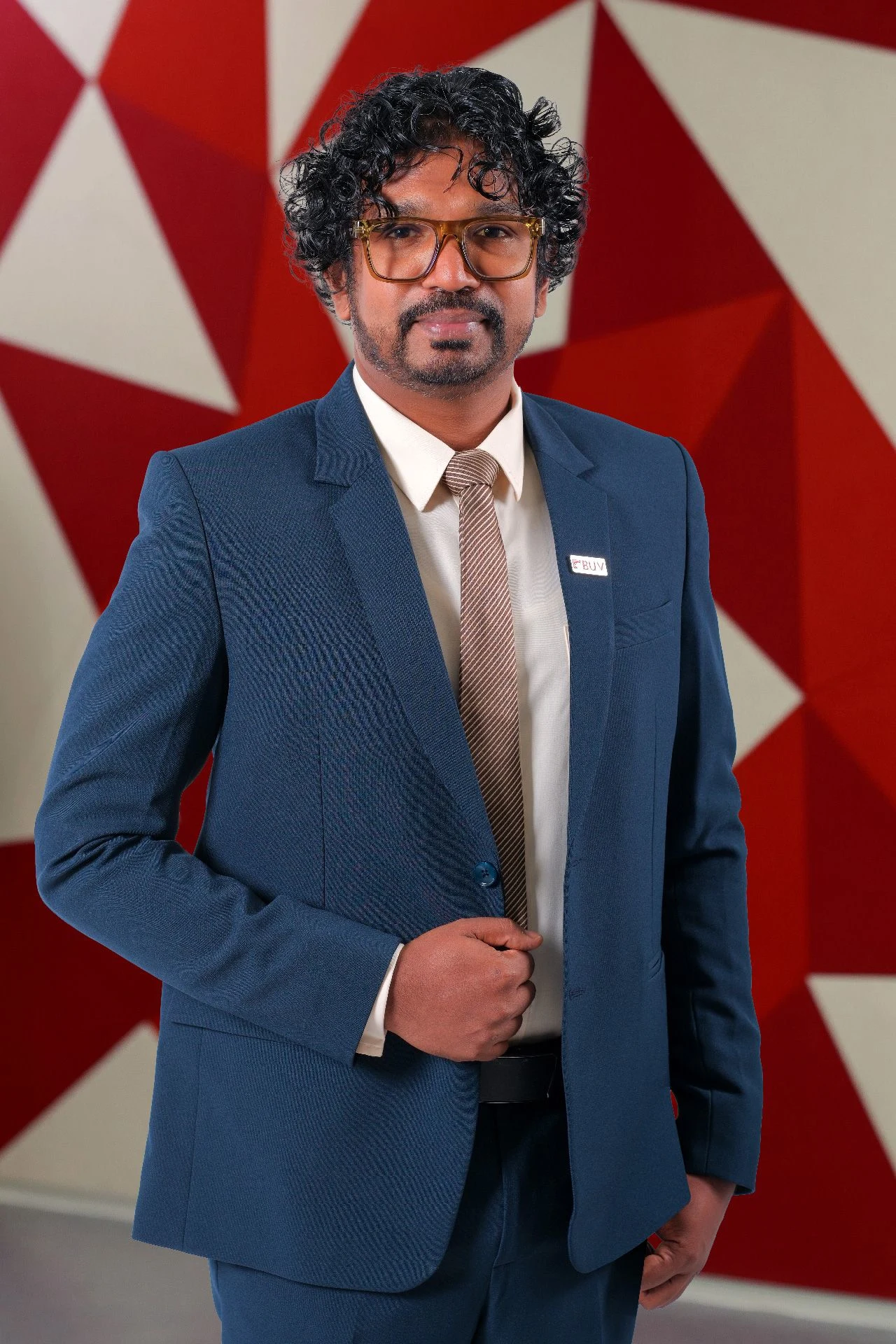 Dr Madura wearing a blue suit and BUV pin at British University Vietnam