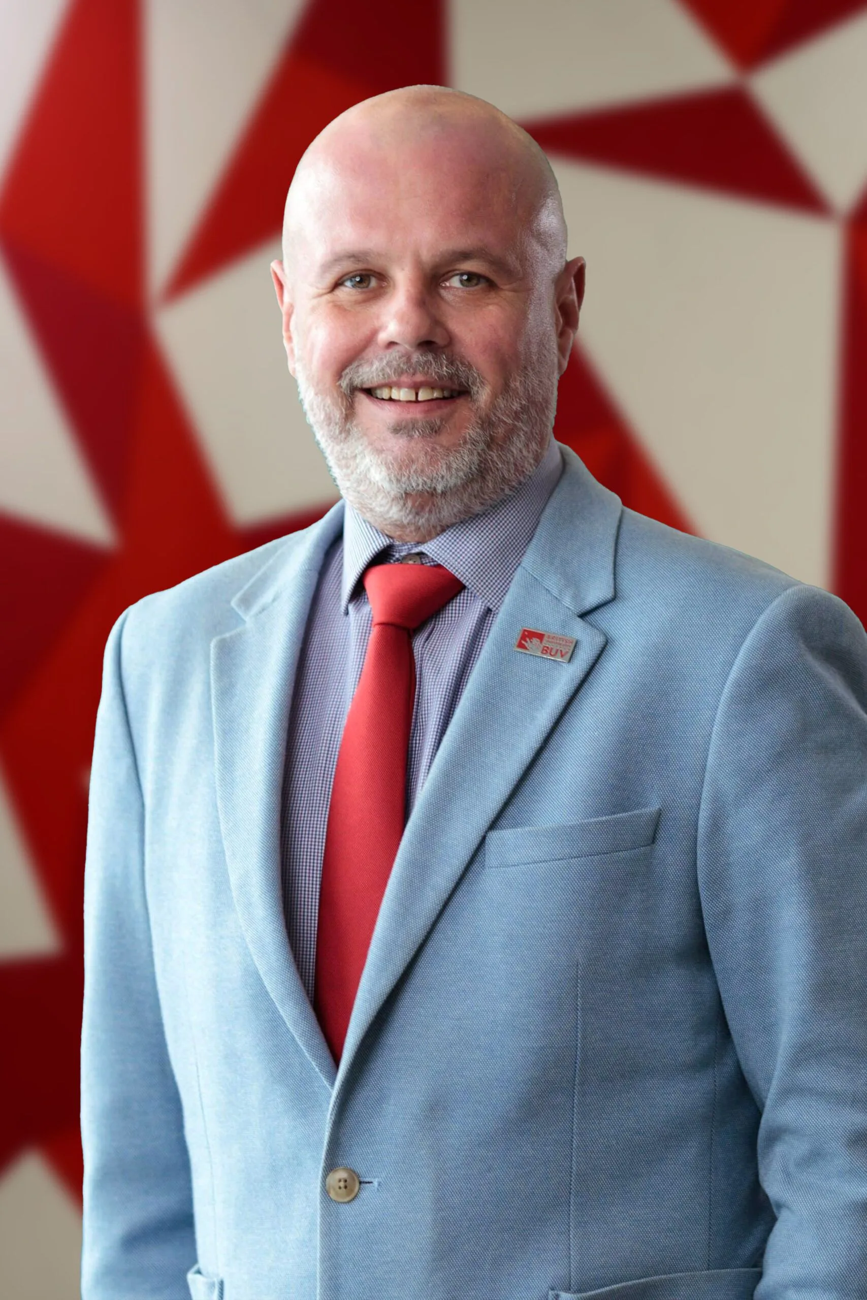 Darius Postma in a light blue suit and red tie at British University Vietnam (BUV)