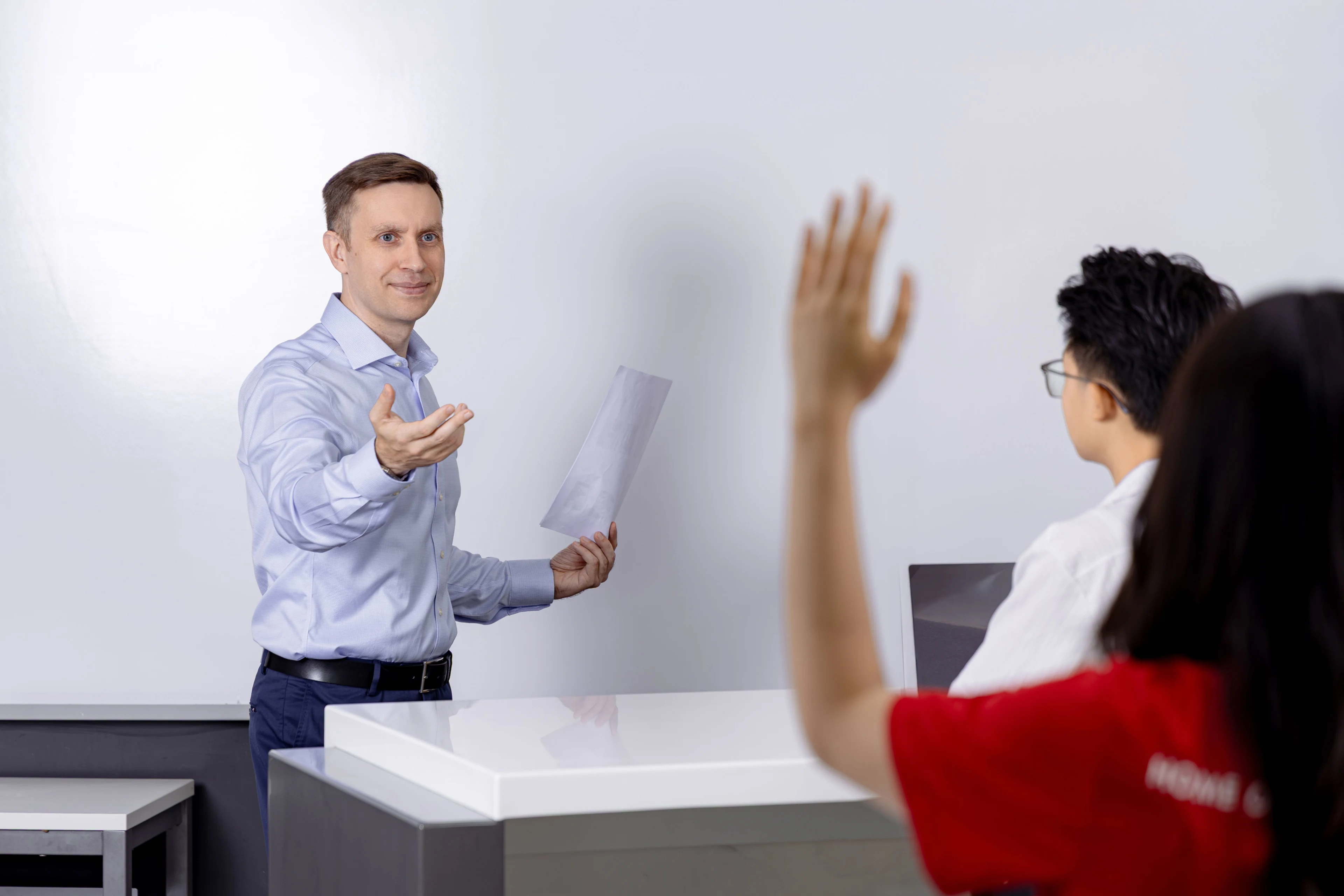 Giảng viên quốc tế BUV tương tác với sinh viên giơ tay phát biểu trong lớp học hiện đại