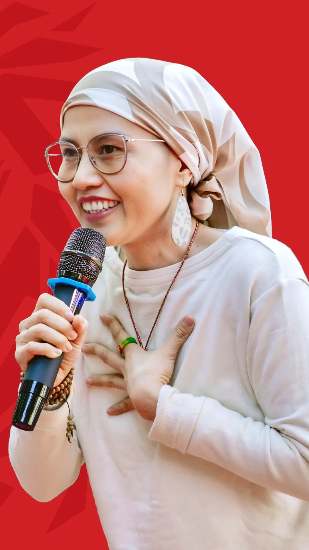 BUV alumna Kim Chung speaking into a microphone against a red background.