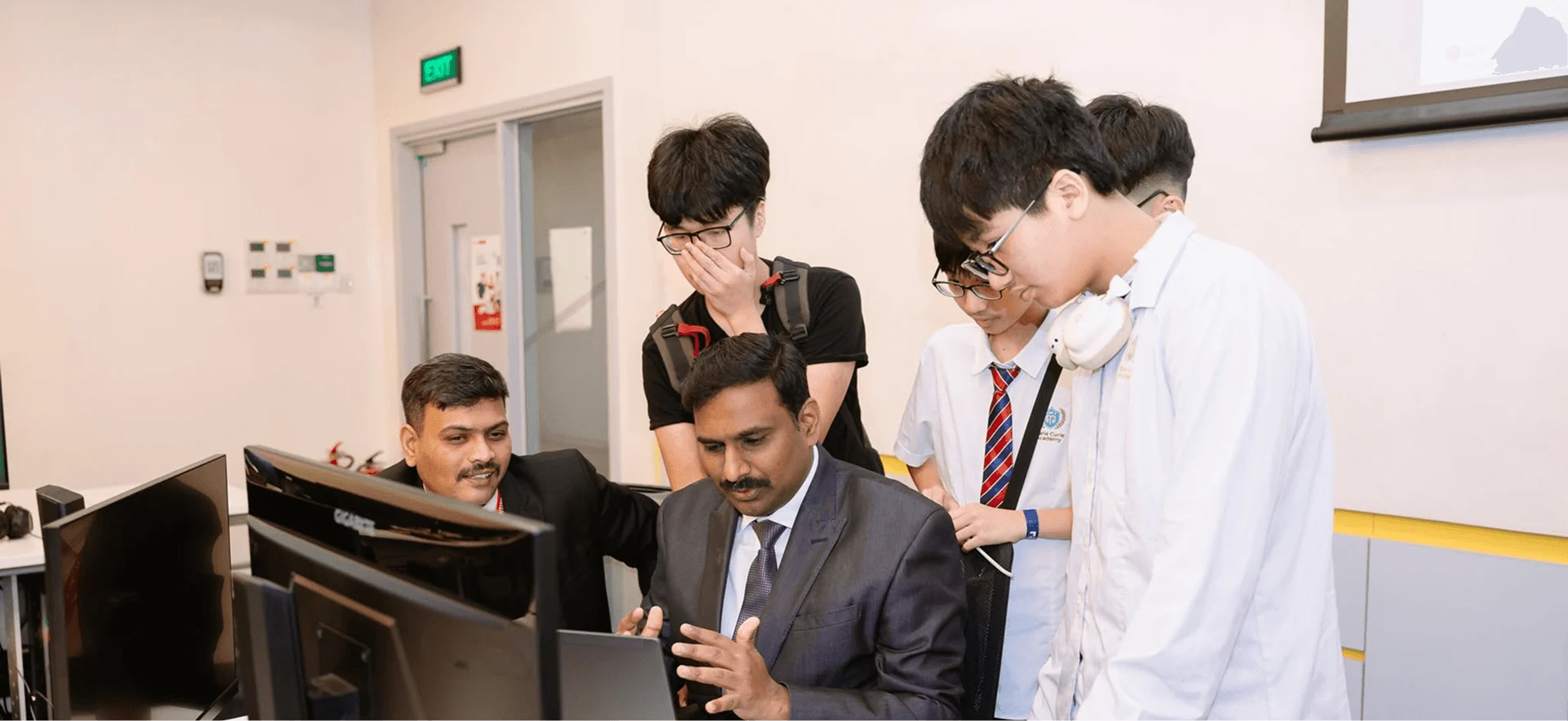 BUV students collaborate with a lecturer in a computer lab during an international learning session