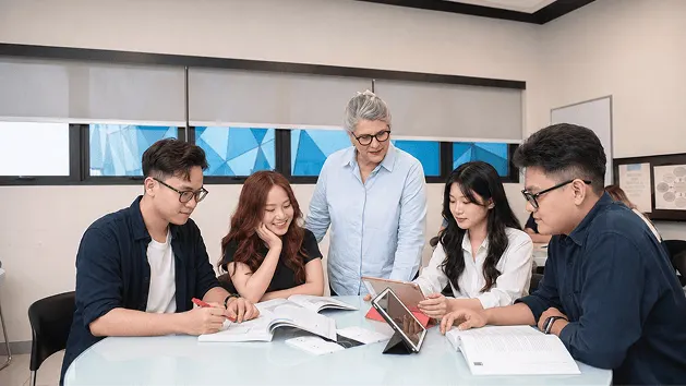 BUV students collaborate with a lecturer during an international university classroom discussion in Vietnam.