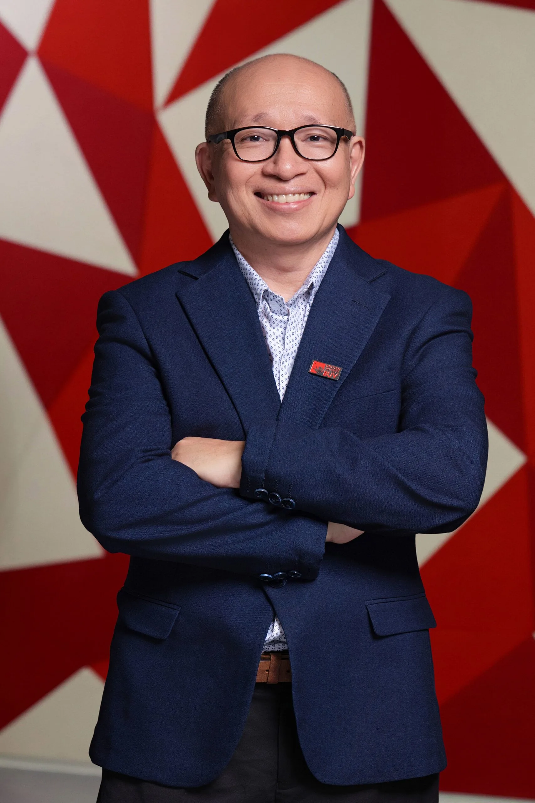 Dr Adrian Weng wearing a navy suit and BUV pin at British University Vietnam