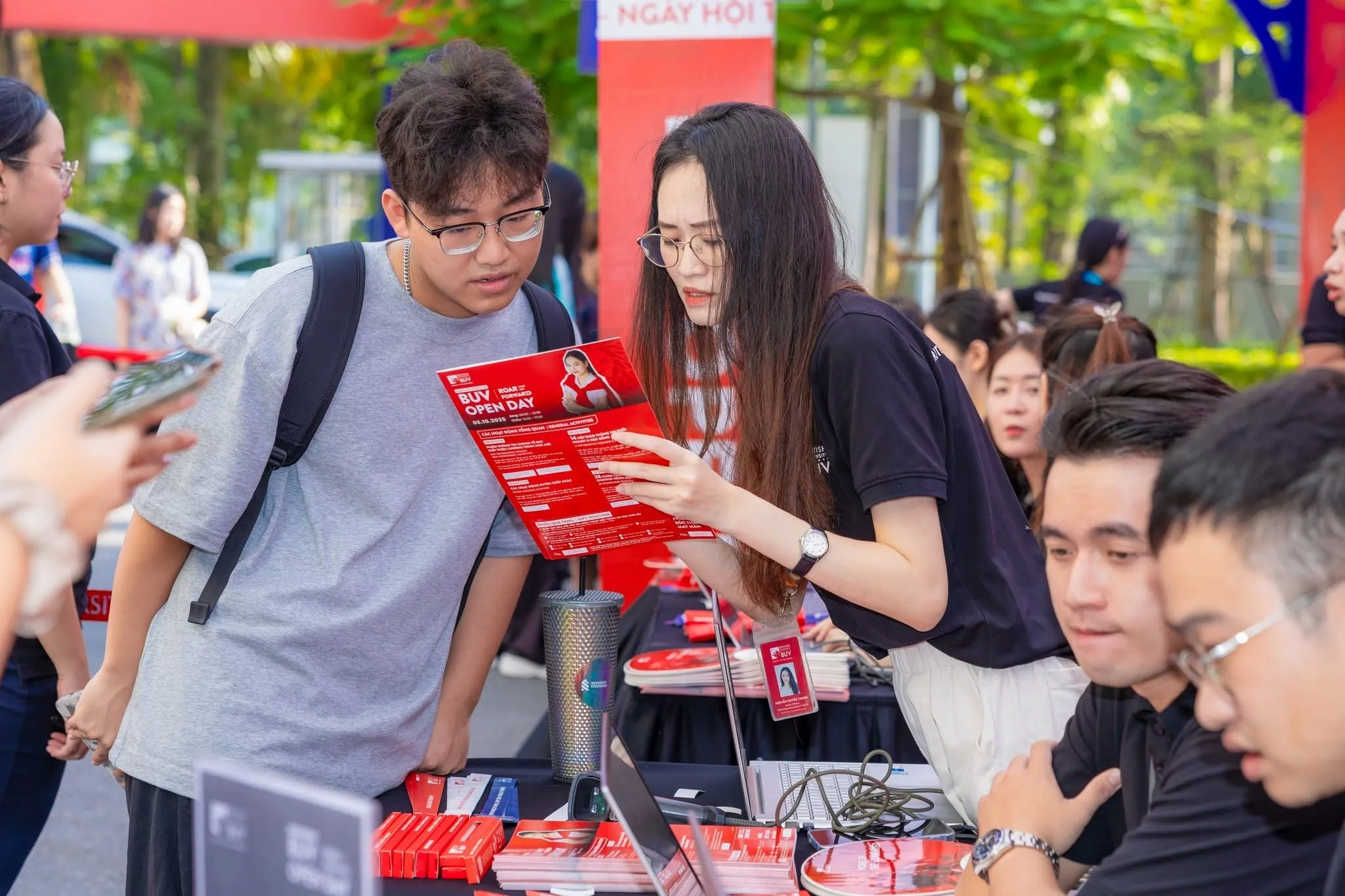 BUV staff member explains fee support information to a prospective student at an event booth.